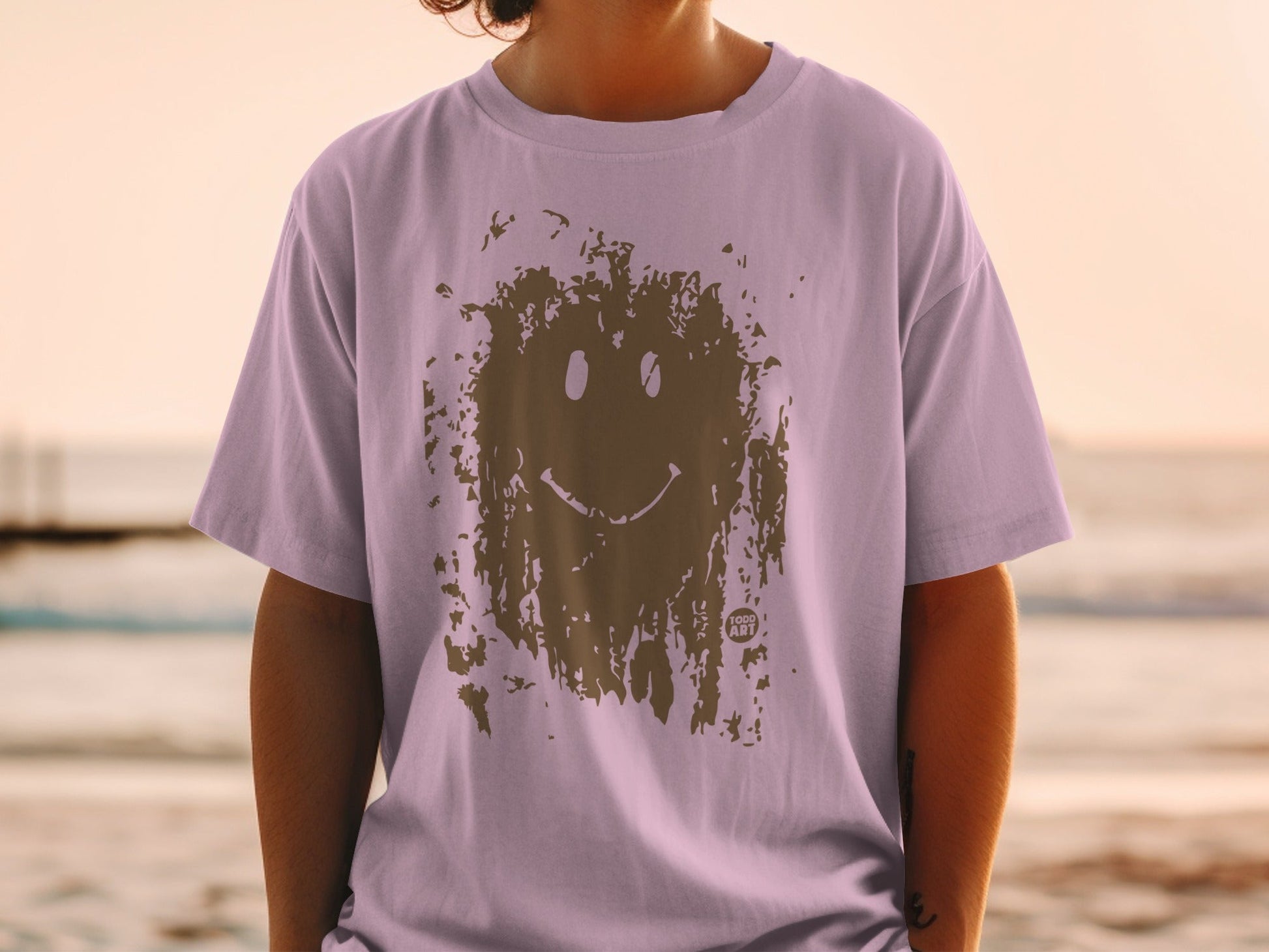 Lavender t-shirt with brown smiley face graphic.