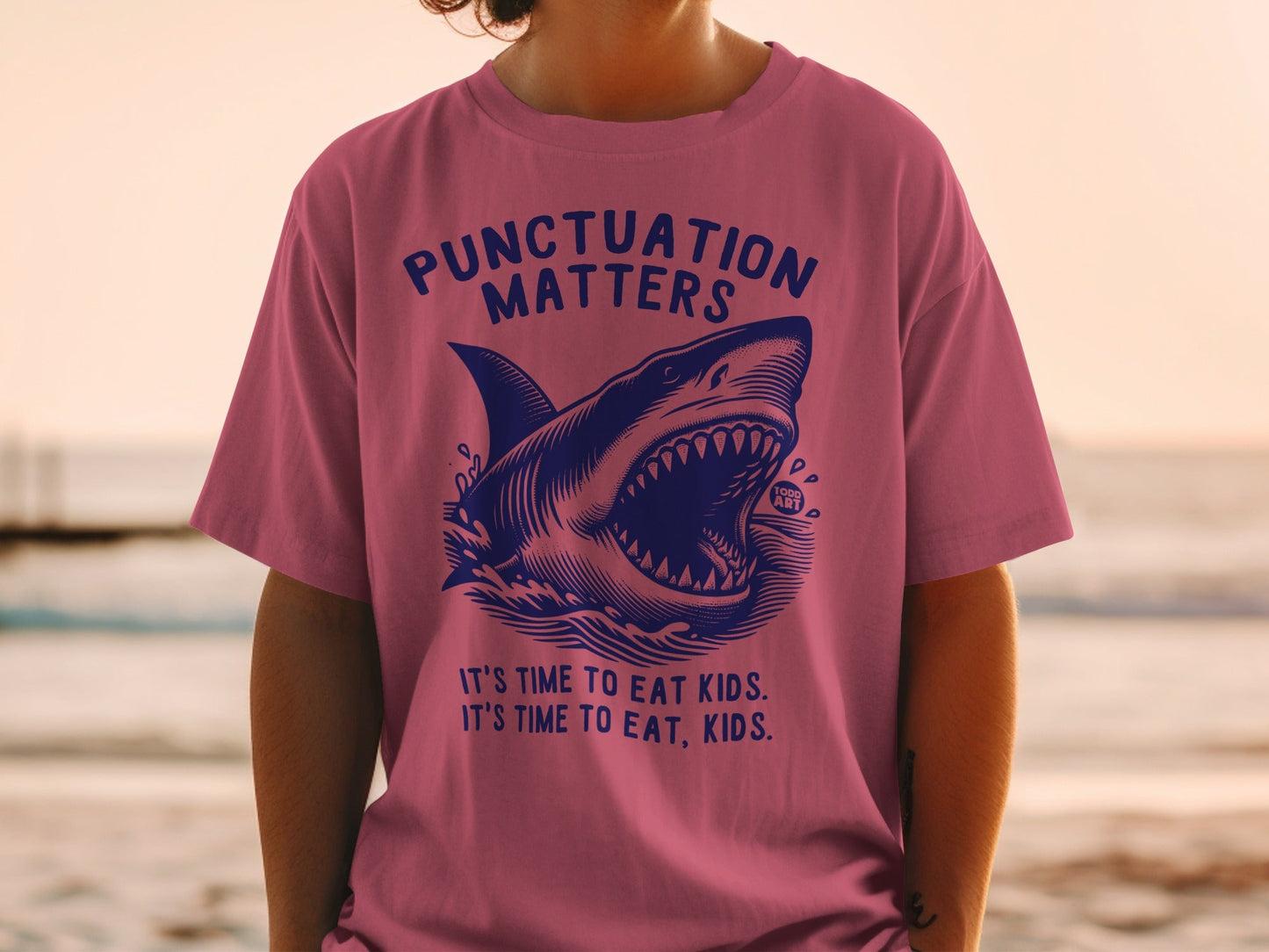Pink t-shirt with a shark and text about punctuation.