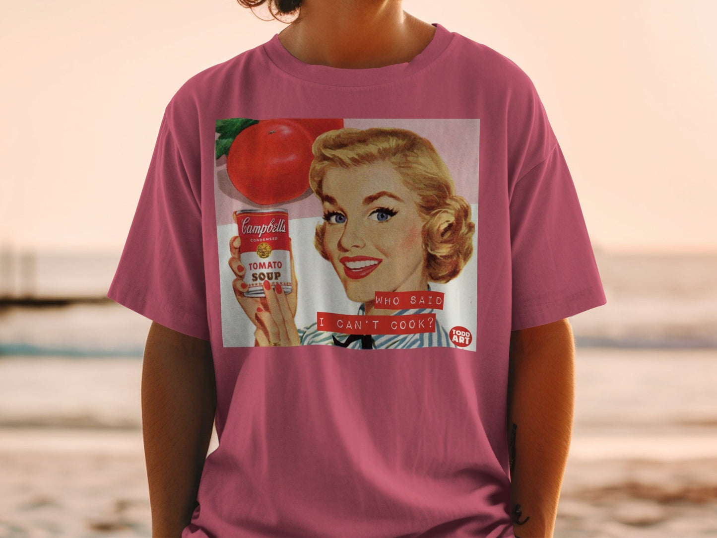 Woman wearing pink shirt featuring retro Campbell's Tomato Soup ad.