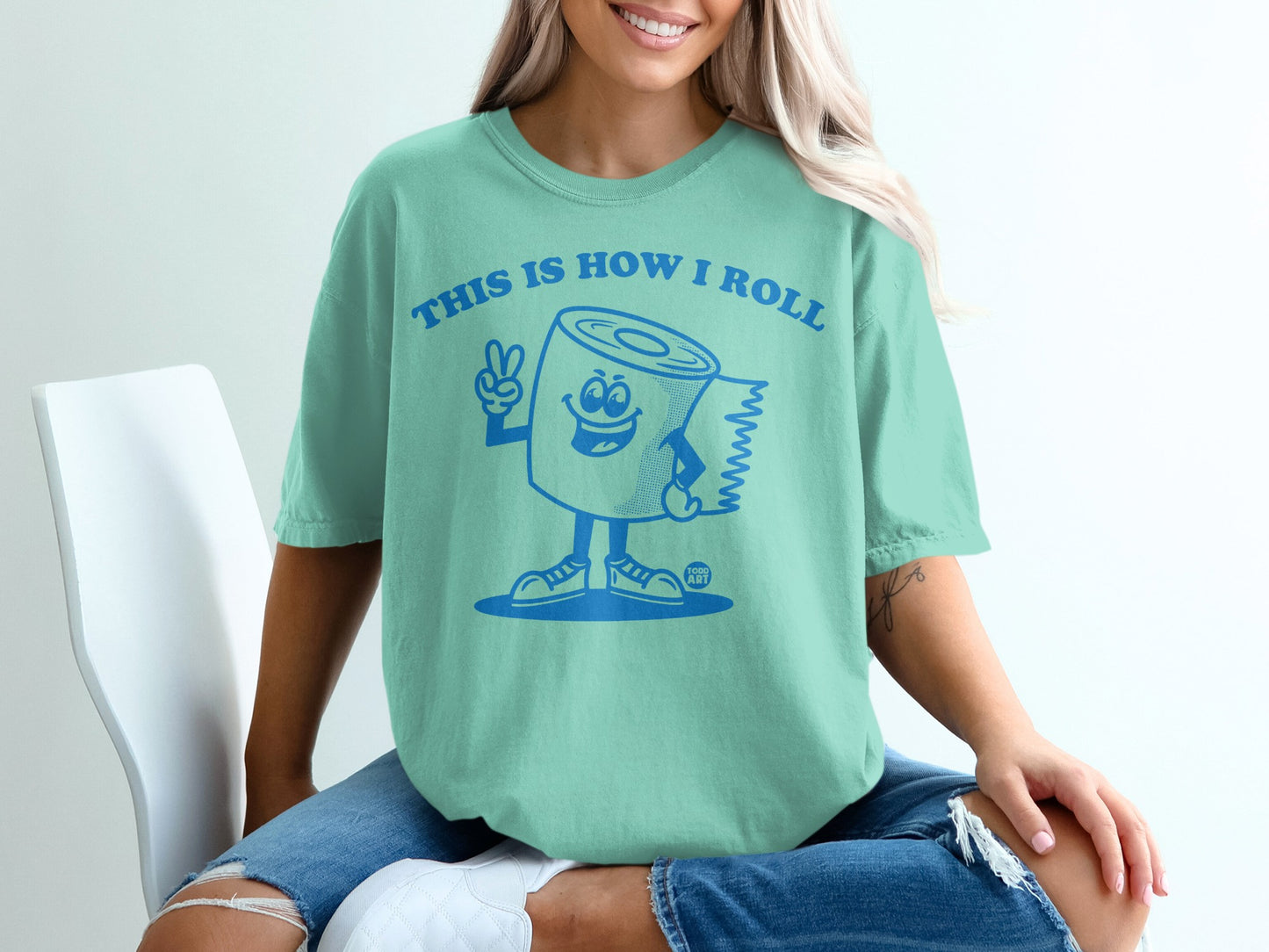 Mint t-shirt with cartoon toilet paper saying "This is how I roll" and peace sign.