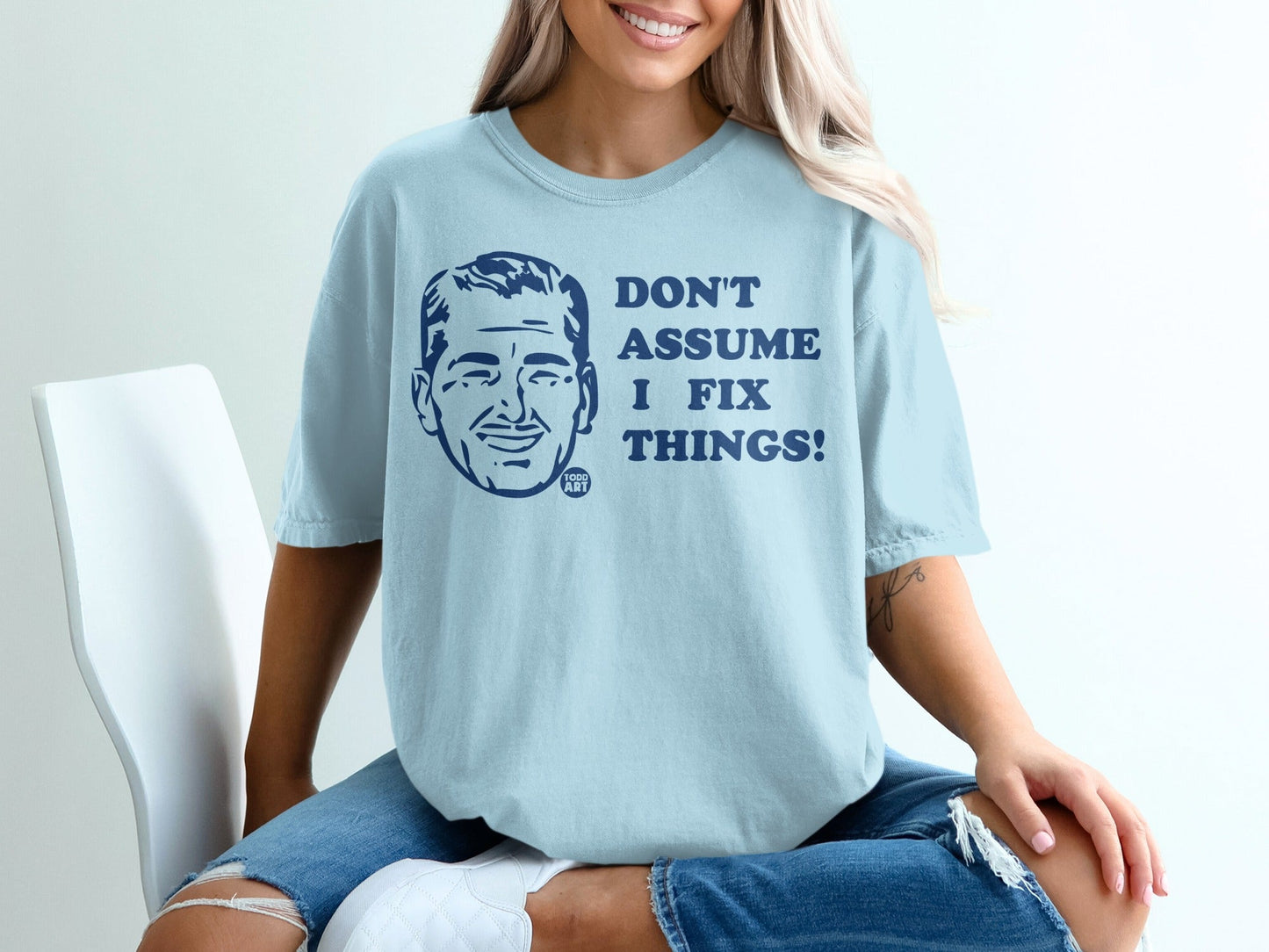 Light blue t-shirt with "DON'T ASSUME I FIX THINGS!" and a man's portrait.