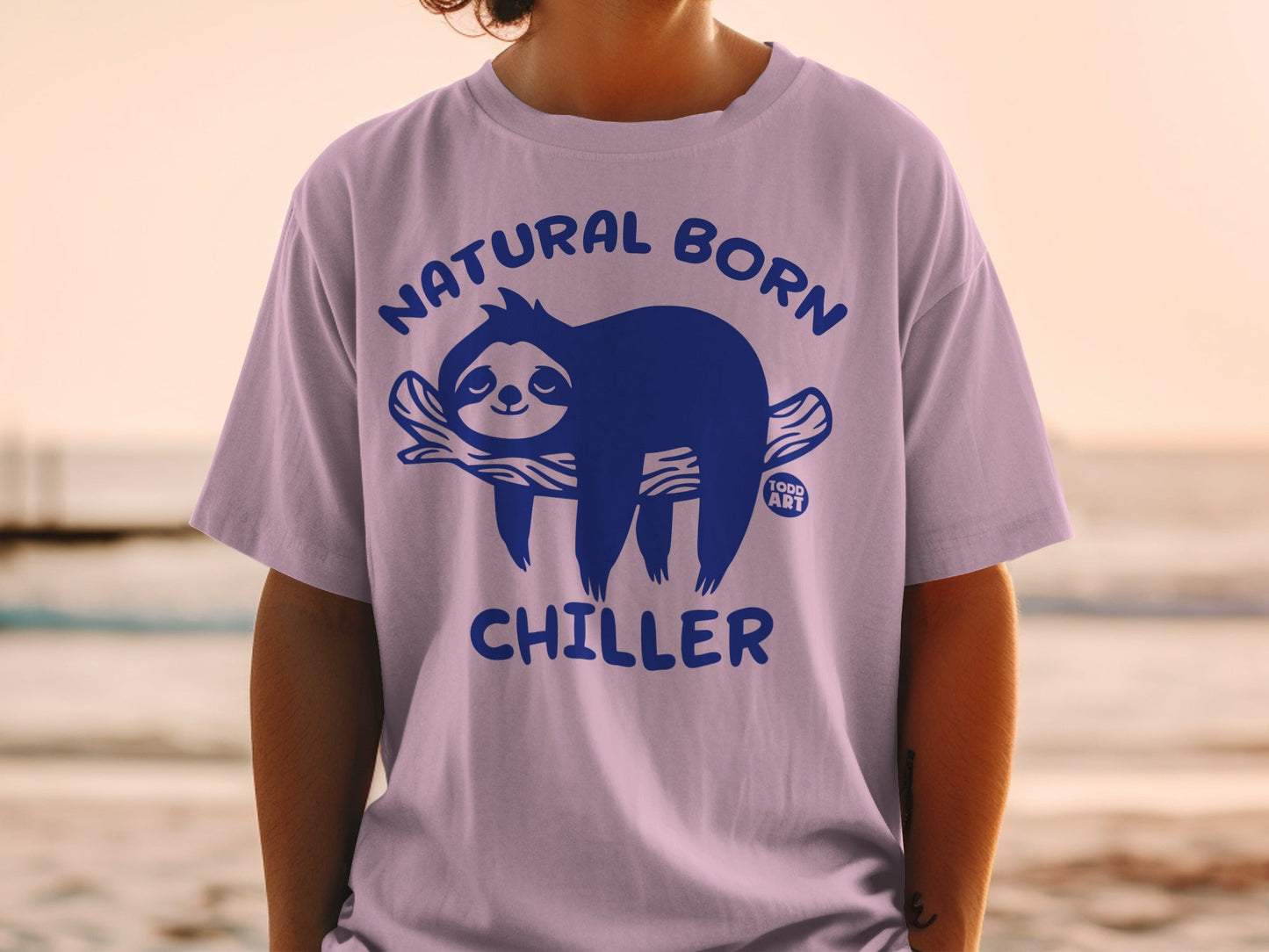 Purple t-shirt with a blue sloth graphic and "Natural Born Chiller" text.