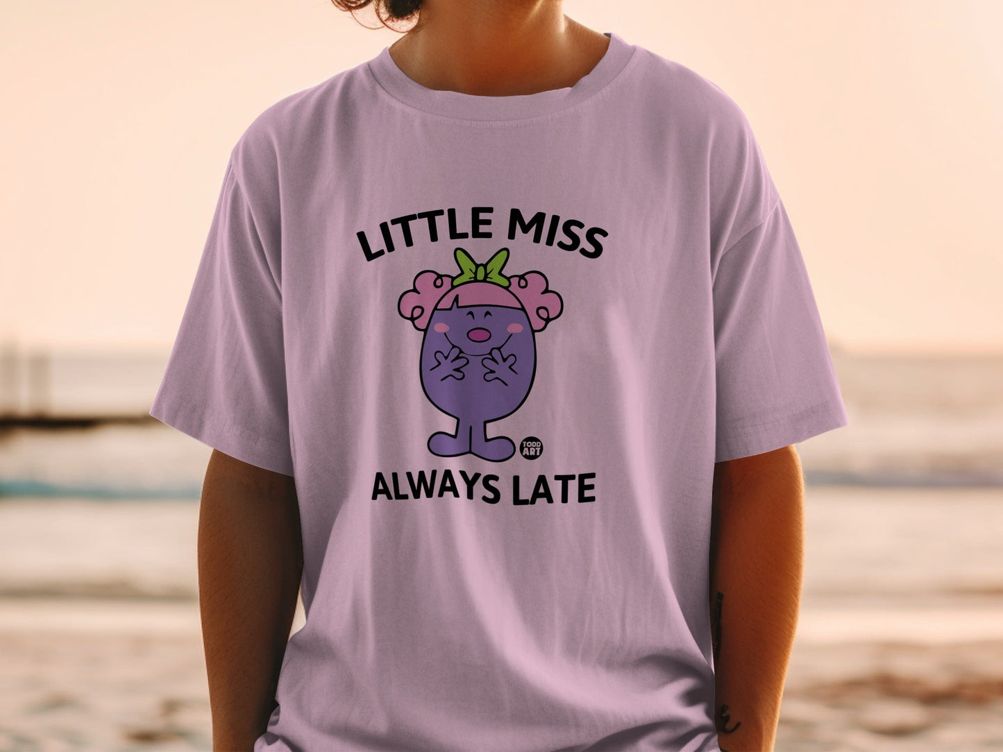 Little Miss Always Late character on a lilac t-shirt.