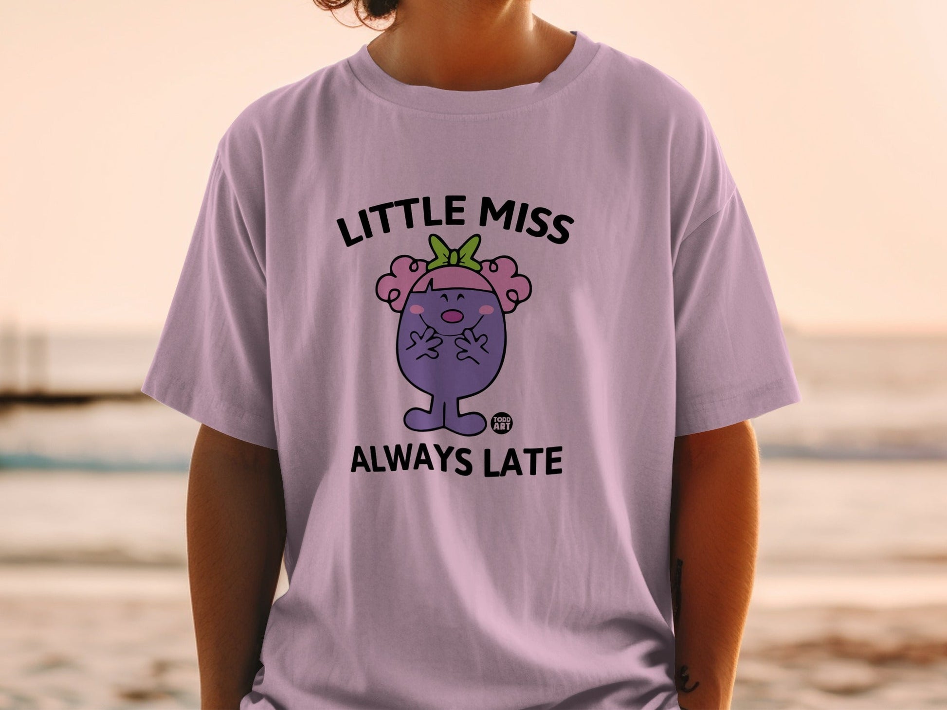 Little Miss Always Late character on a lilac t-shirt.