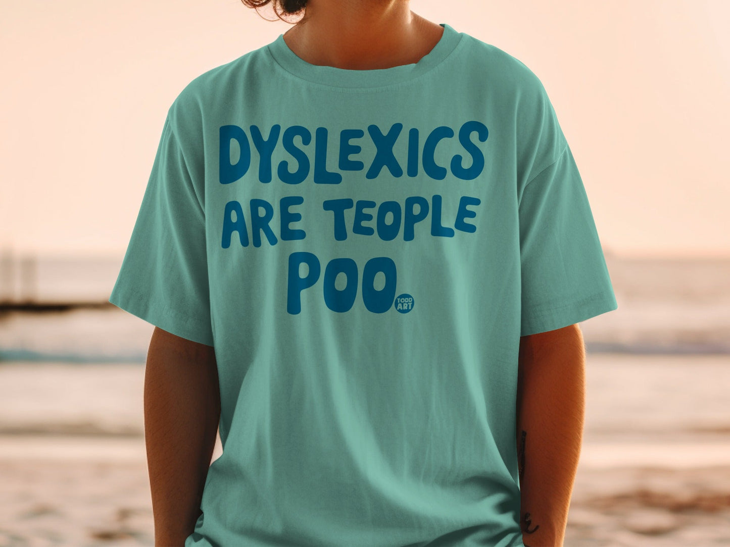Teal t-shirt with bold blue text: "DYSLEXICS ARE TEOPLE POO".
