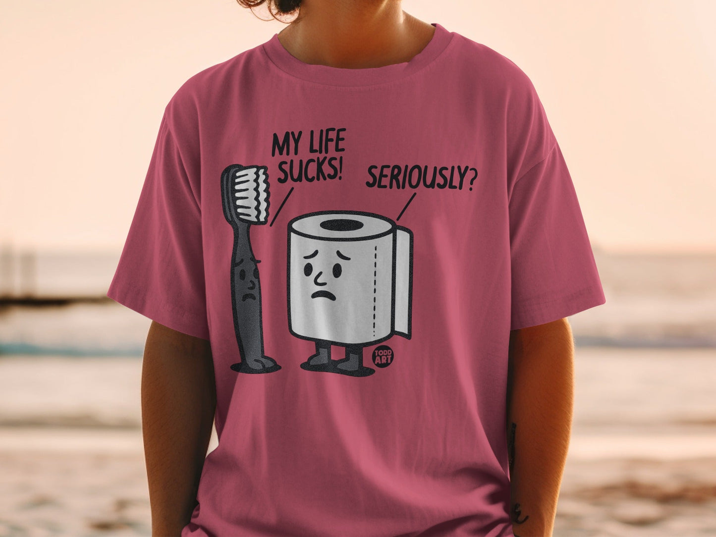 T-shirt with cartoon toothbrush and toilet paper characters and text.