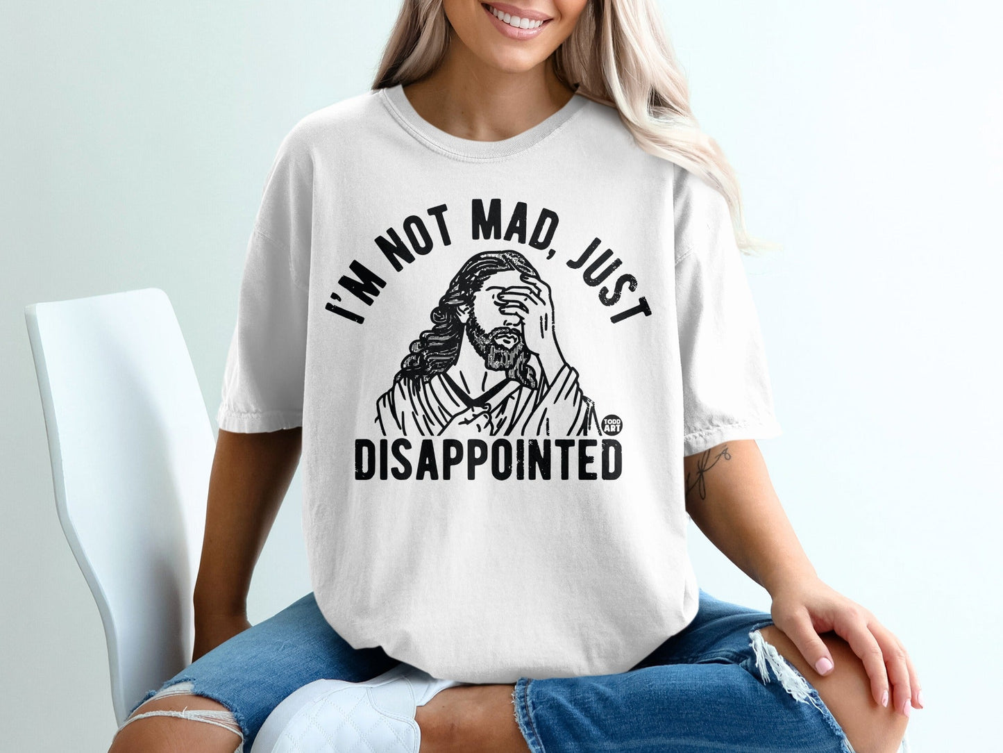 White t-shirt with black text: "I'M NOT MAD, JUST DISAPPOINTED" and an illustration of Jesus.