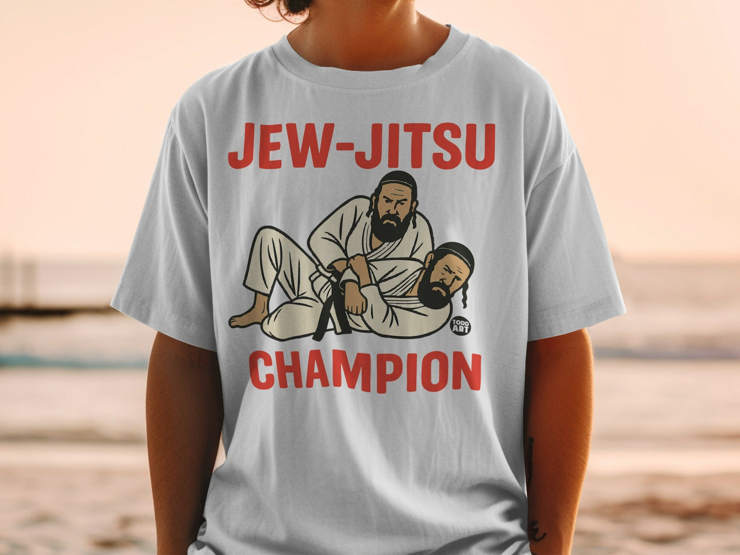 White t-shirt with "JEW-JITSU CHAMPION" and cartoon of two men wrestling.