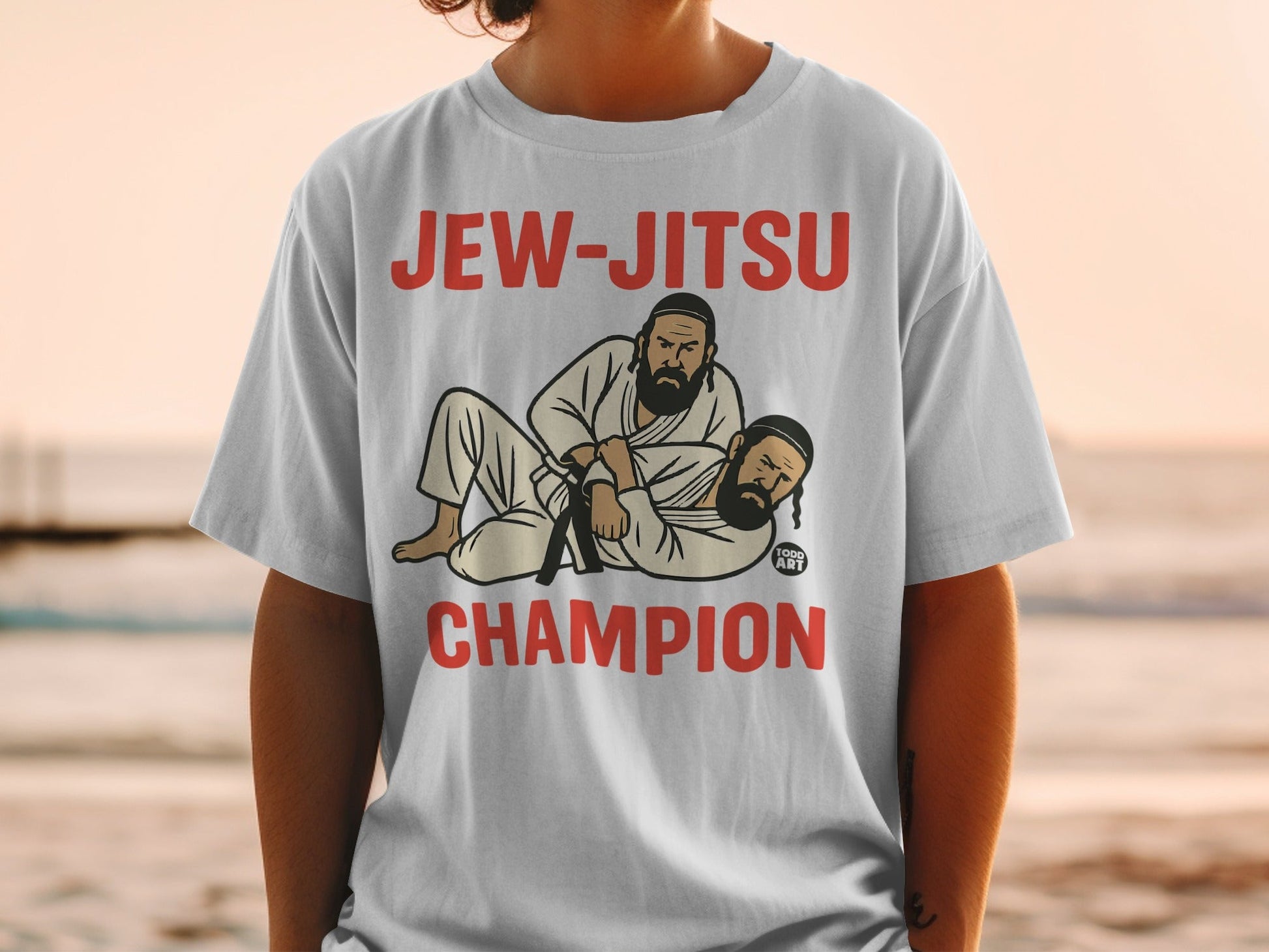 White t-shirt with "JEW-JITSU CHAMPION" and cartoon of two men wrestling.