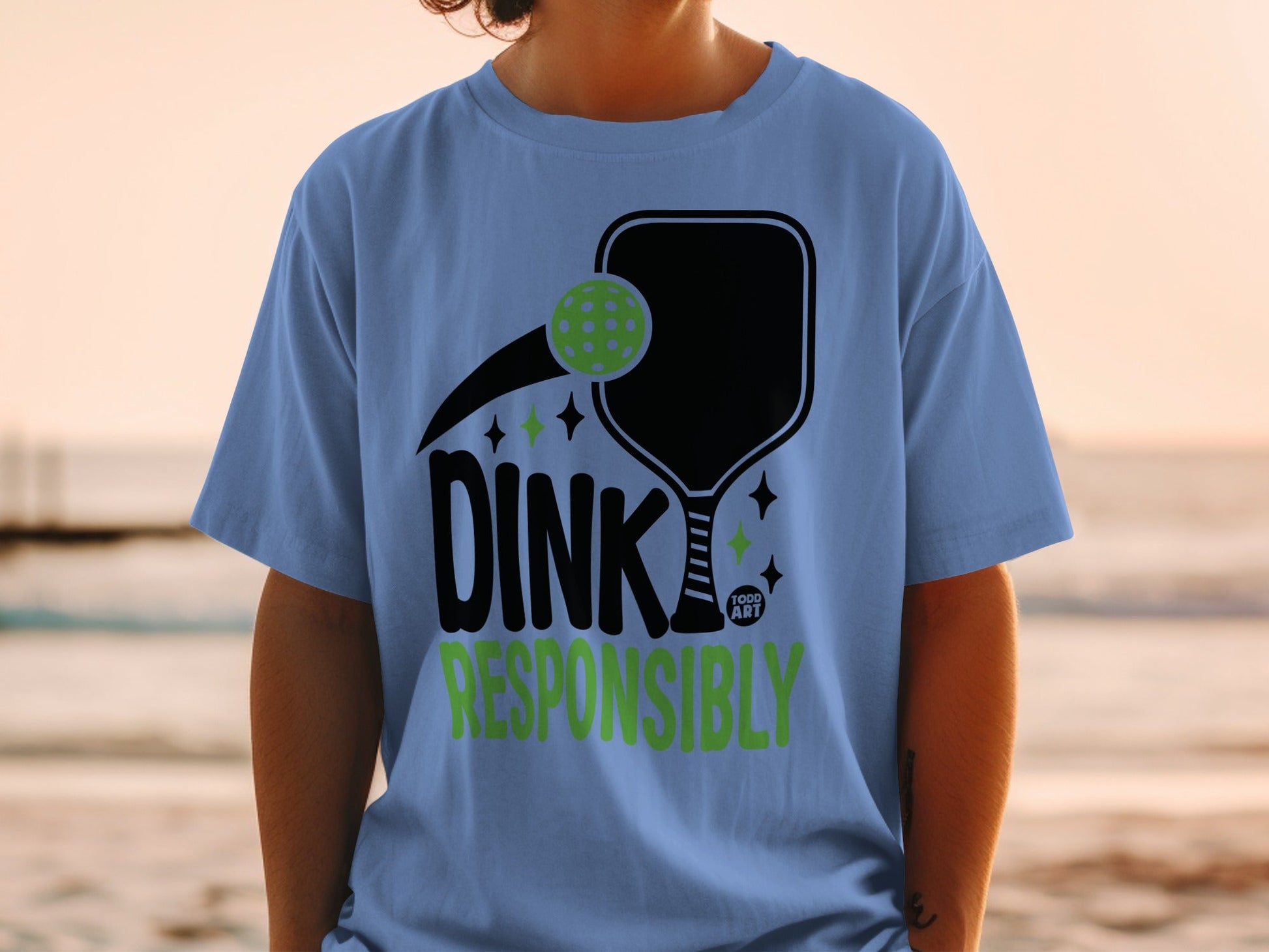 Blue t-shirt with pickleball paddle, ball, and "DINK RESPONSIBLY" text.