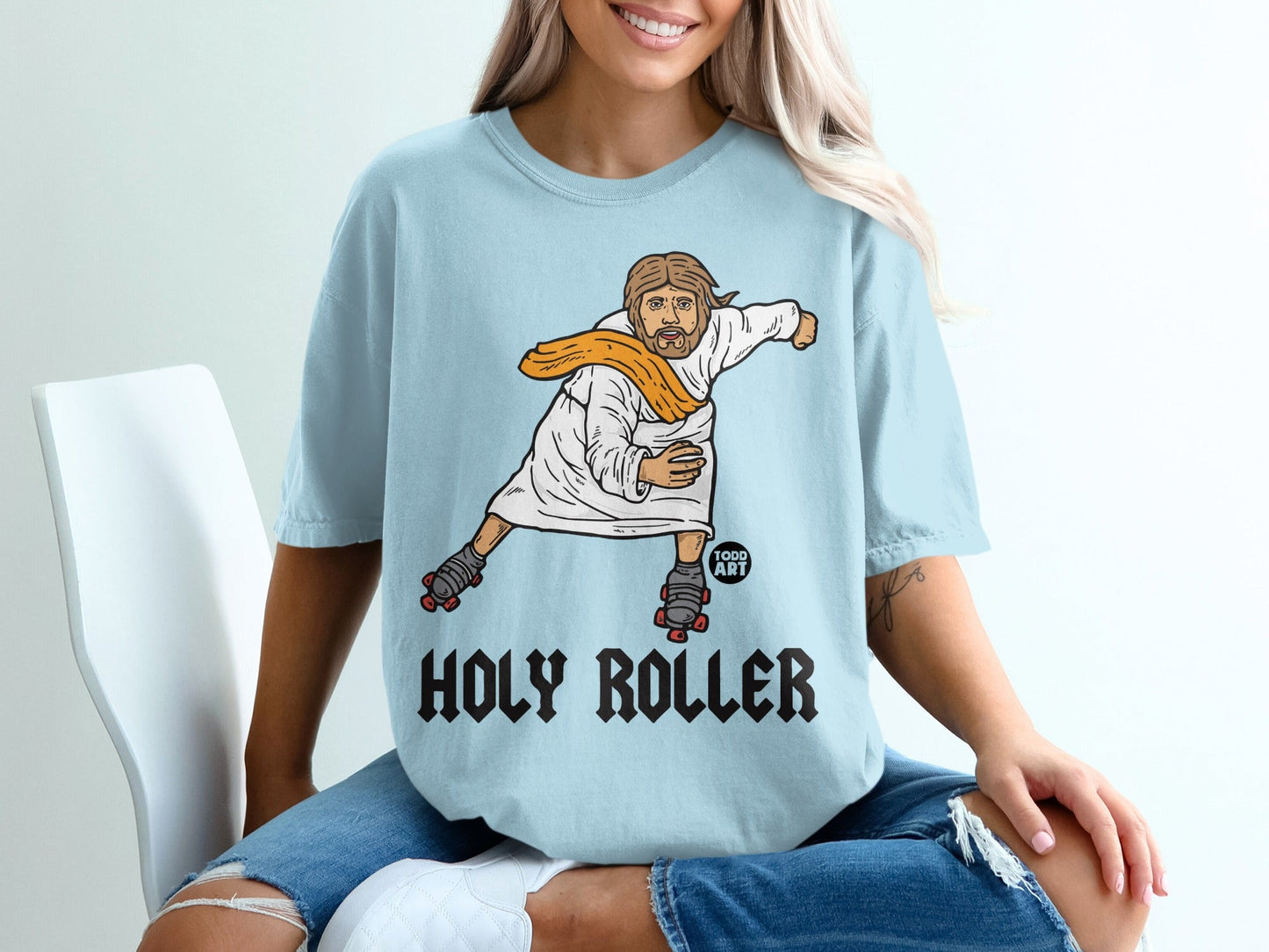 Jesus on roller skates wearing an orange scarf, text reads "HOLY ROLLER."