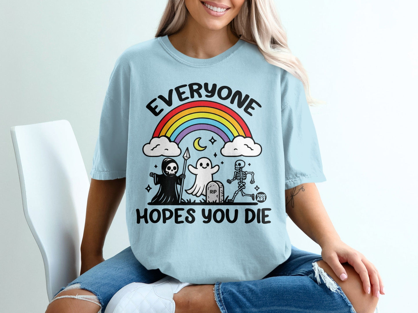 Light blue t-shirt with "Everyone Hopes You Die" and cartoon ghosts and skeletons.