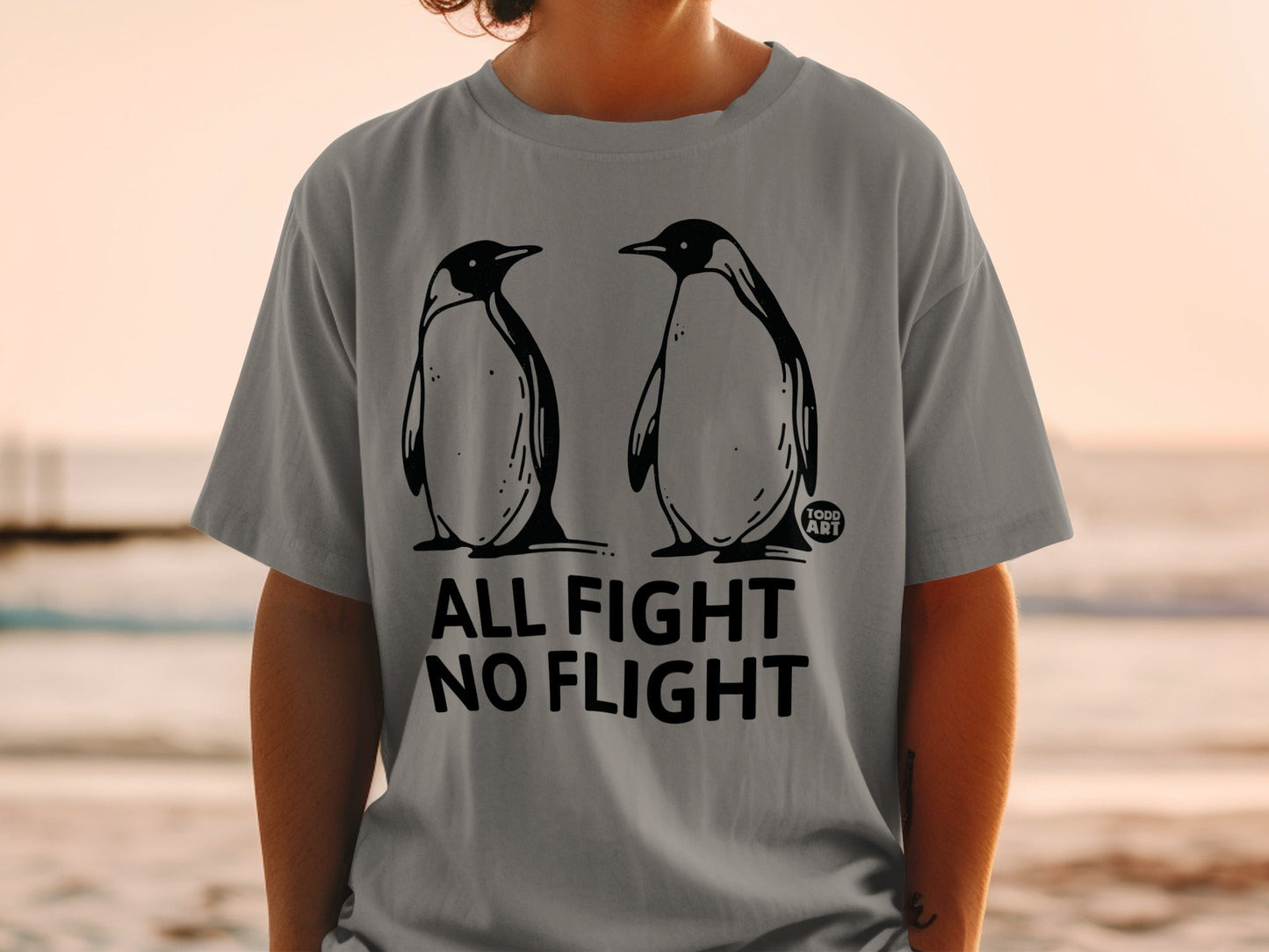 Gray t-shirt with two penguins and text "ALL FIGHT NO FLIGHT".