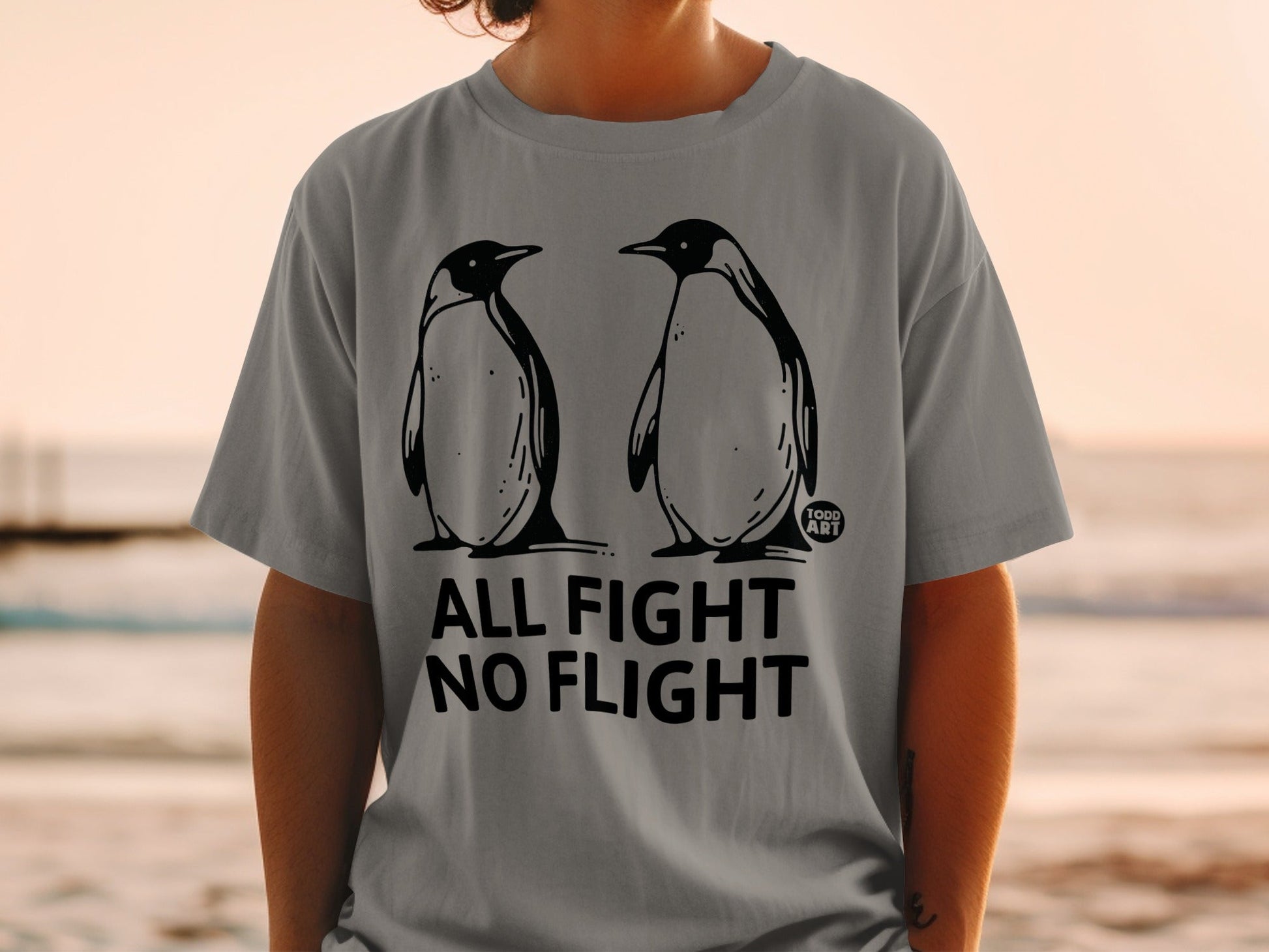 Gray t-shirt with two penguins and text "ALL FIGHT NO FLIGHT".
