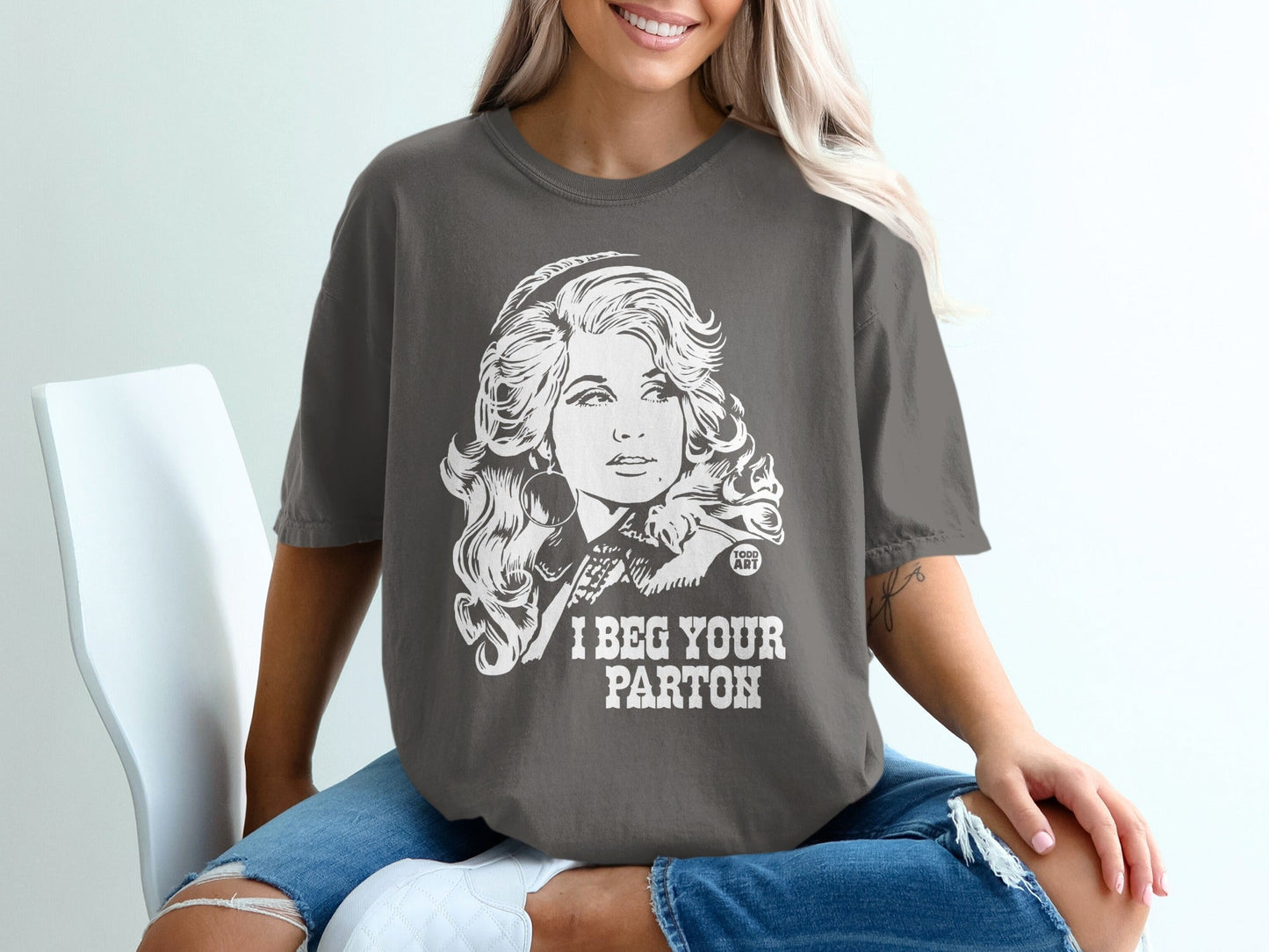 Gray t-shirt with "I Beg Your Parton" and Dolly Parton graphic.