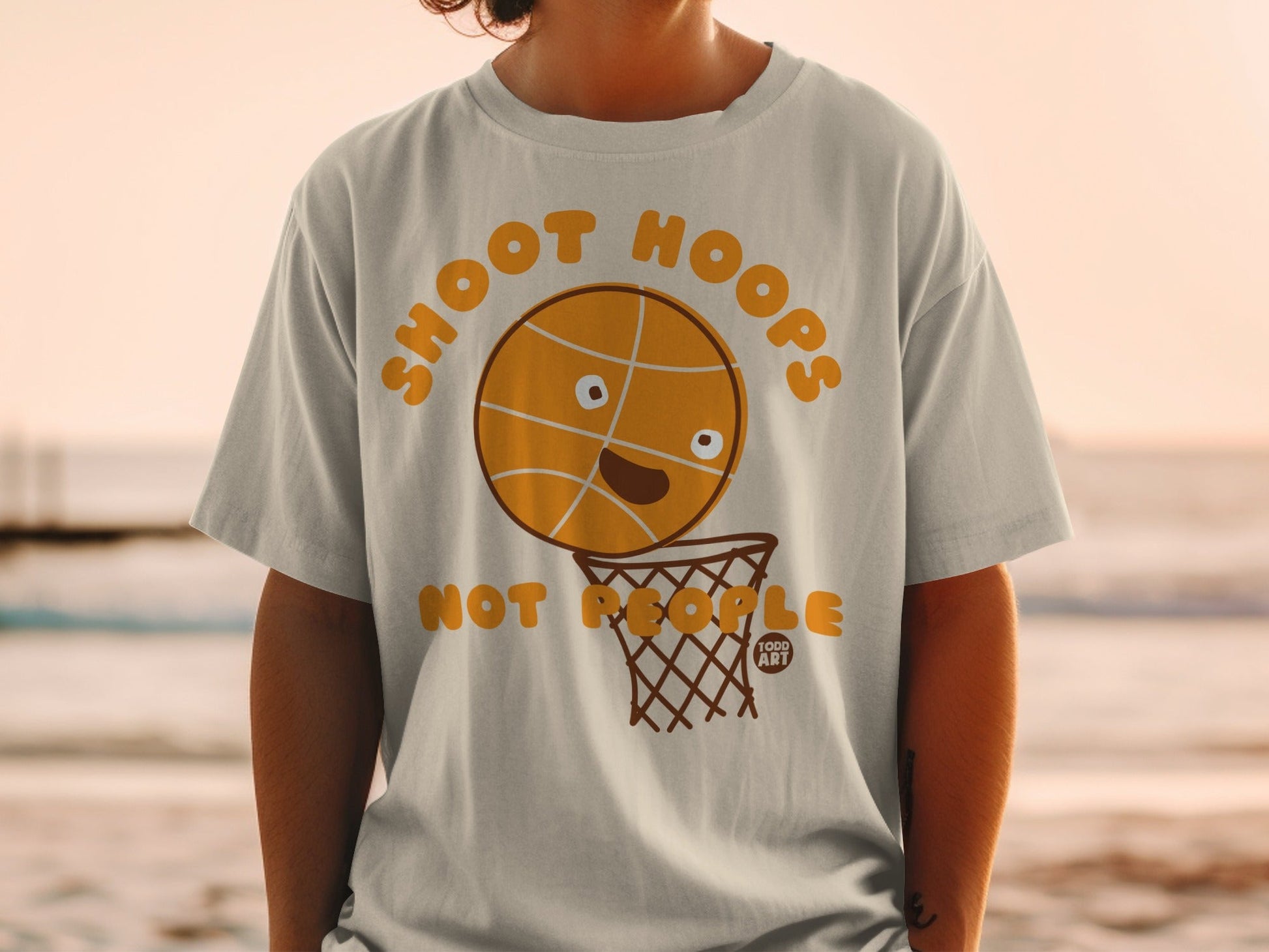 T-shirt with a smiling basketball about to be shot into a hoop.