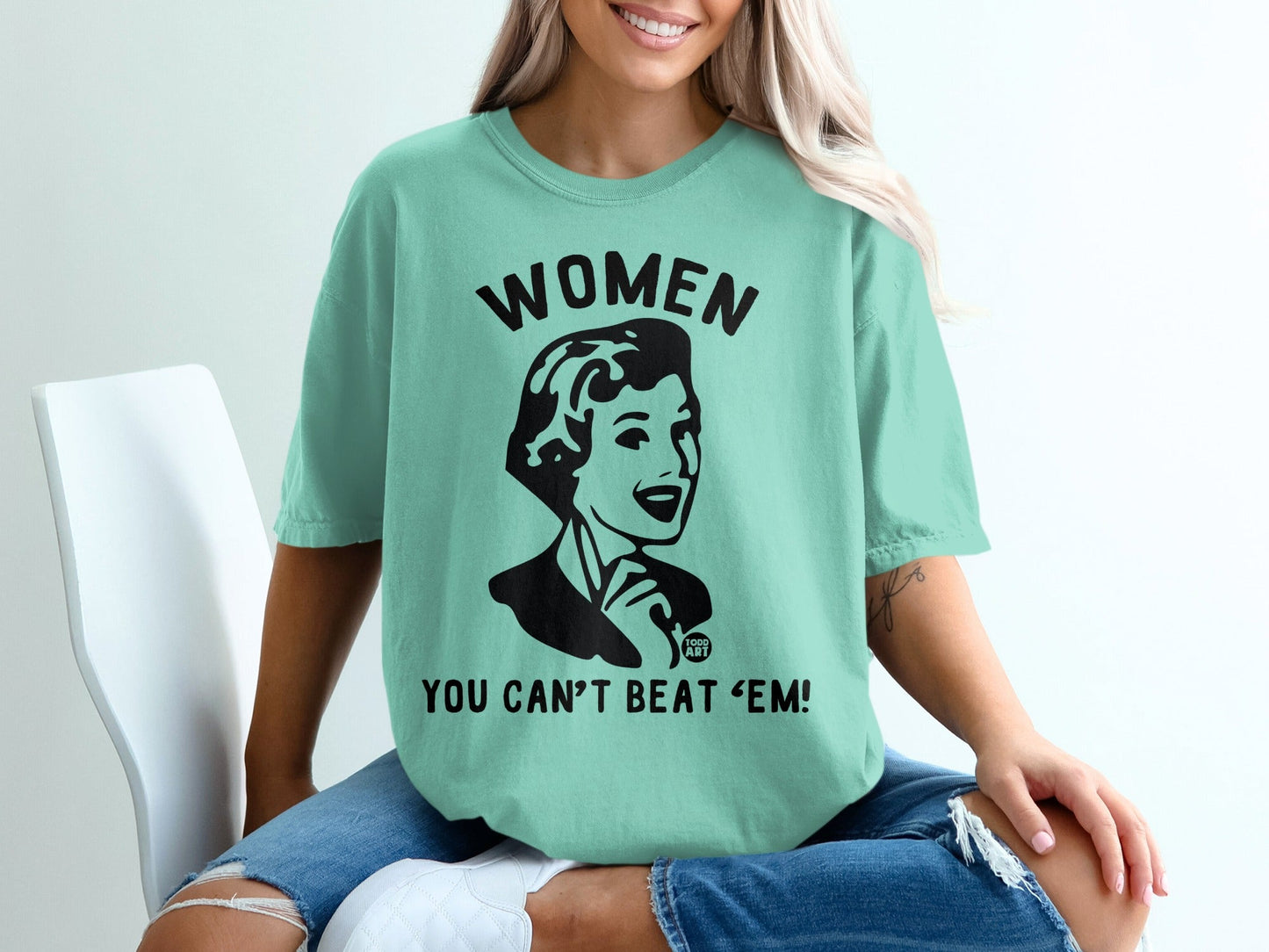 Teal t-shirt with black graphic: "WOMEN YOU CAN'T BEAT 'EM!"