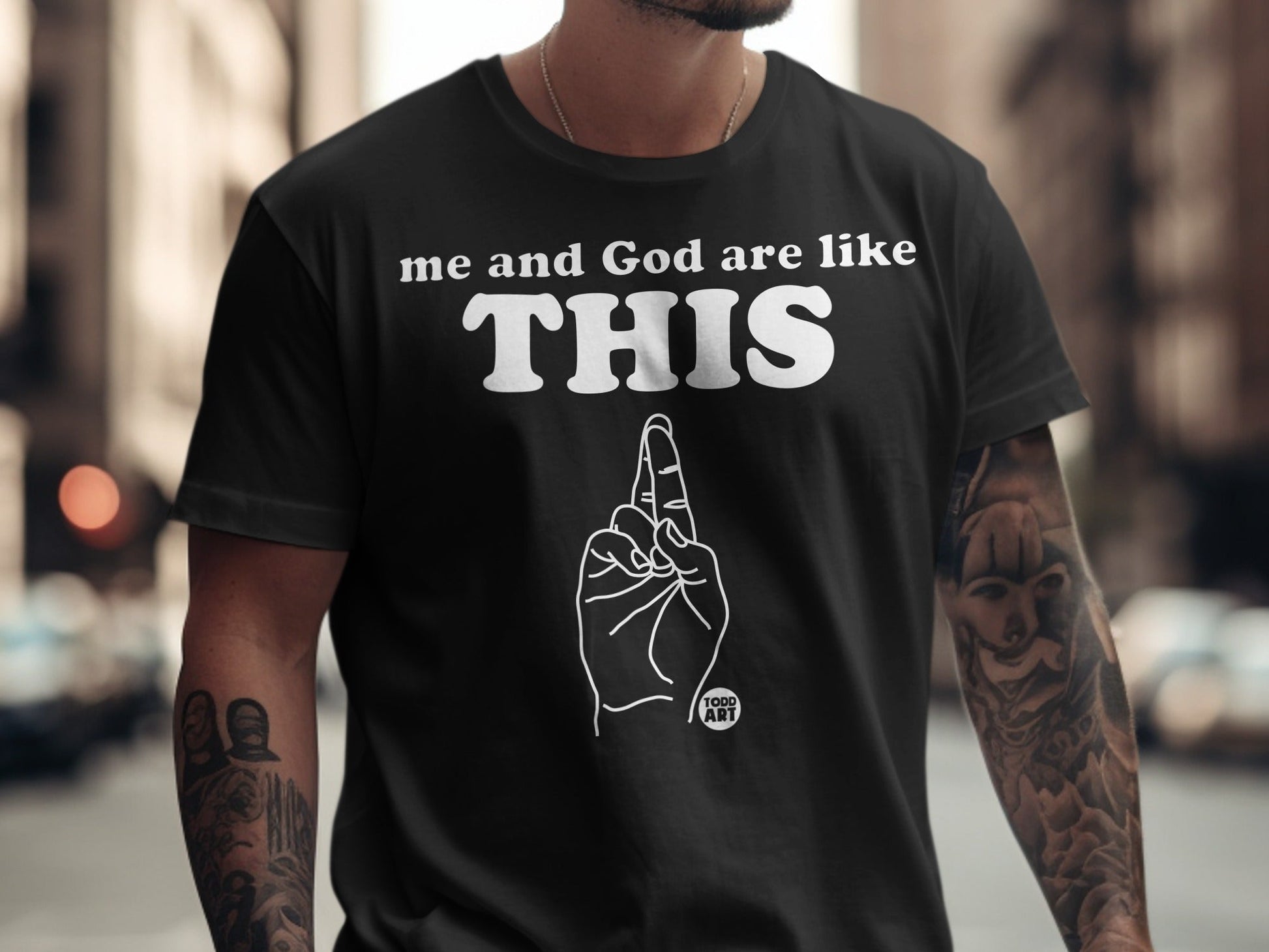 Black t-shirt with "me and God are like THIS" and a hand gesture.