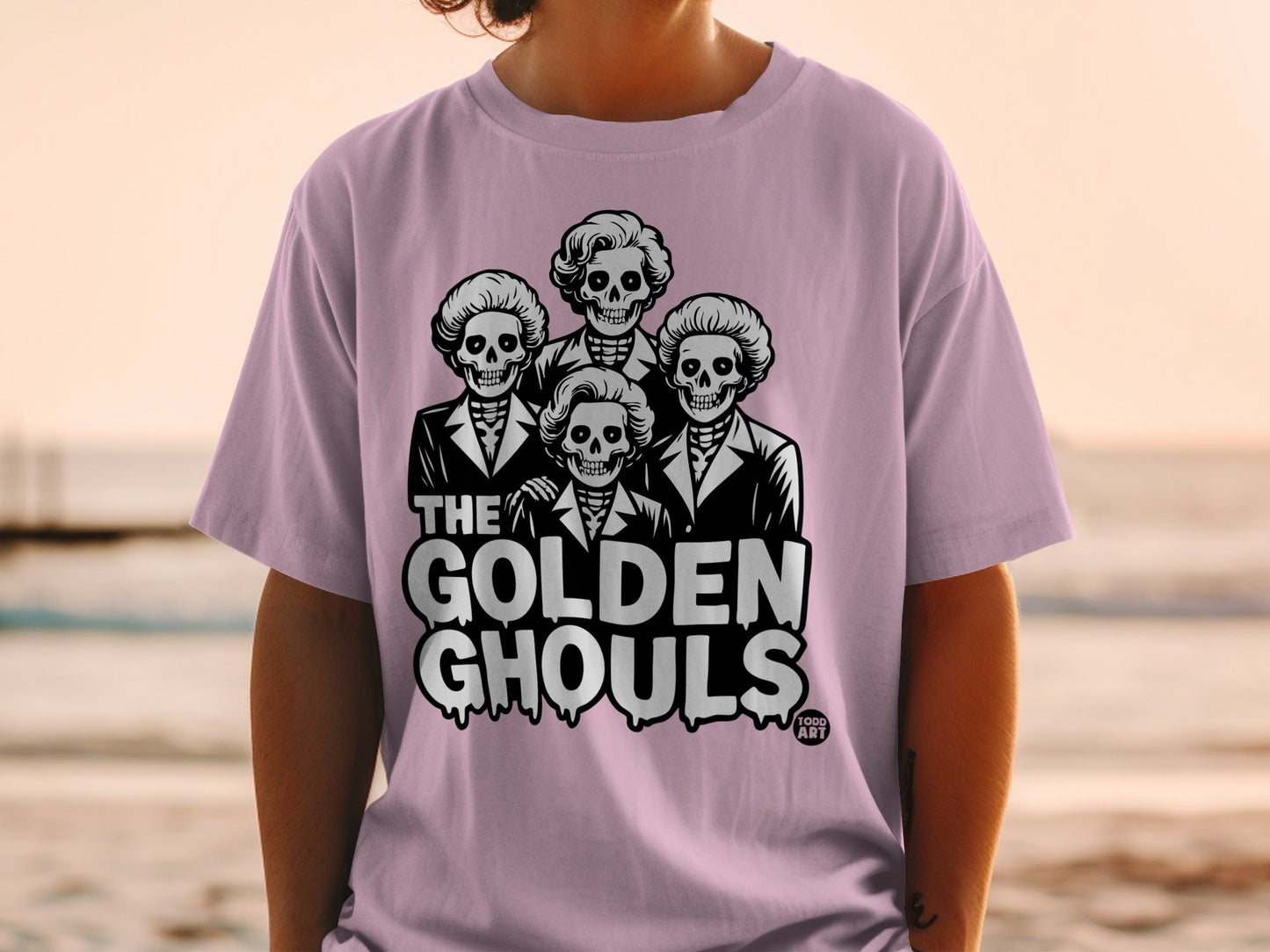 Pink t-shirt with "The Golden Ghouls" skulls in suits graphic.