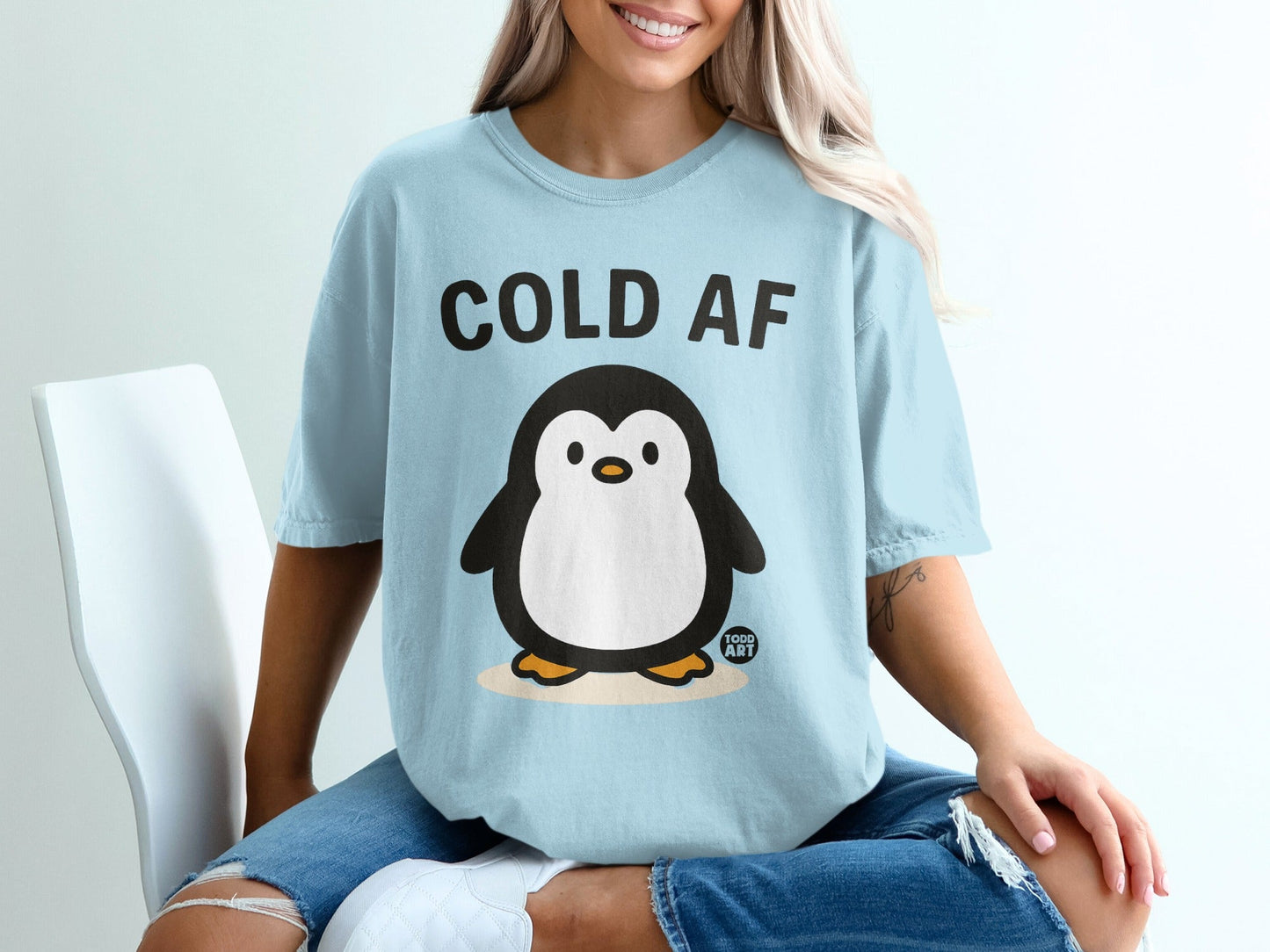 Light blue t-shirt with cartoon penguin and "COLD AF" text.