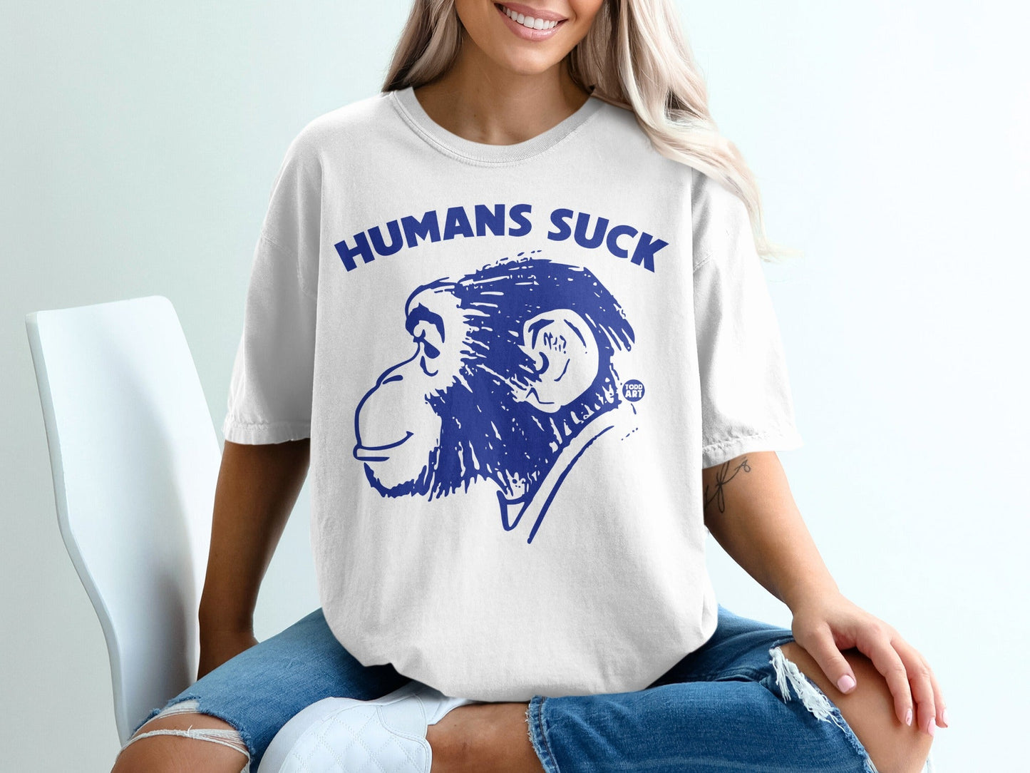 White t-shirt with blue text "HUMANS SUCK" and monkey graphic.