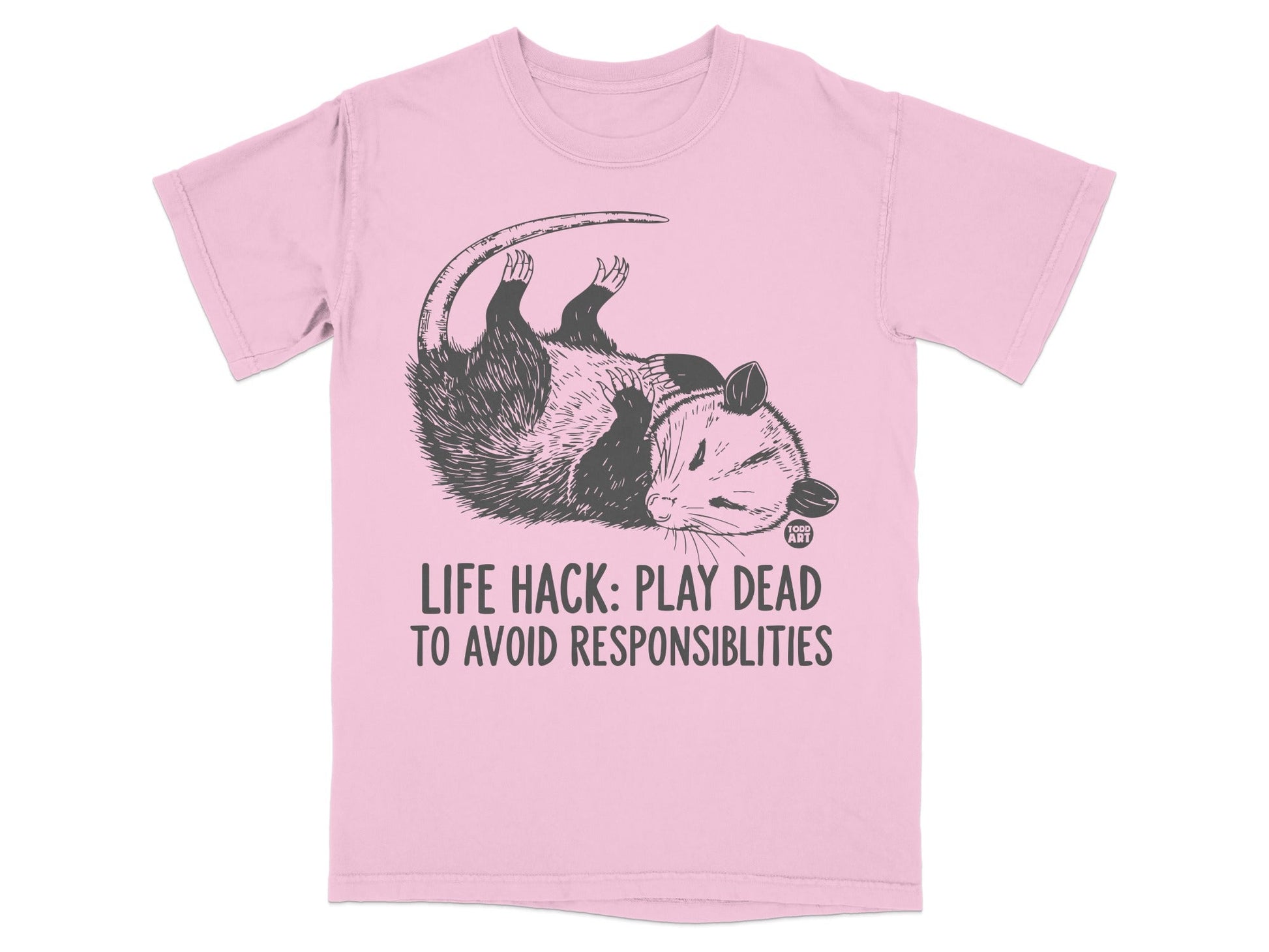 Pink t-shirt with a dead opossum graphic and text "LIFE HACK: PLAY DEAD TO AVOID RESPONSIBILITIES".