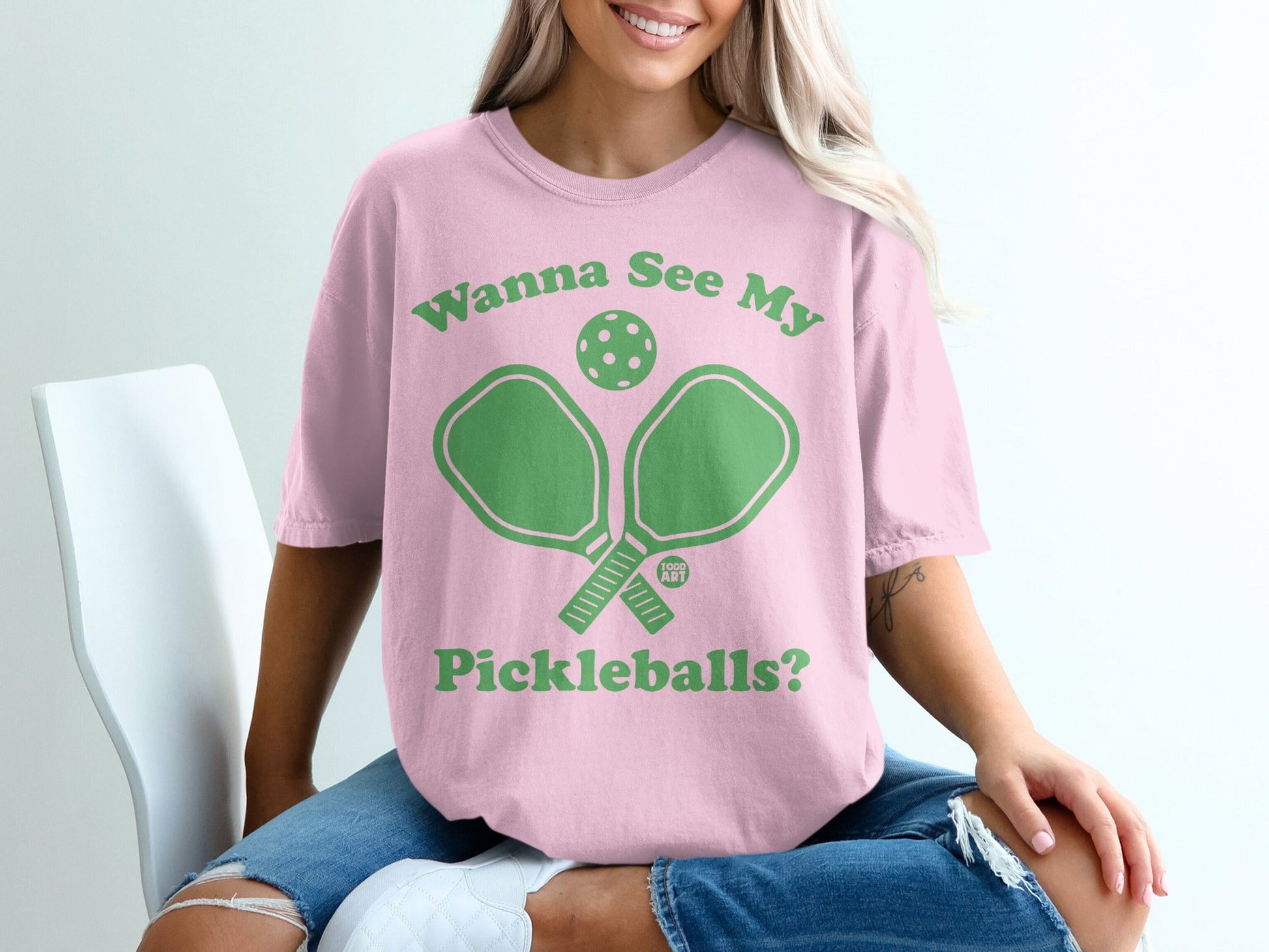 Pink t-shirt with green pickleball paddles and text "Wanna See My Pickleballs?"