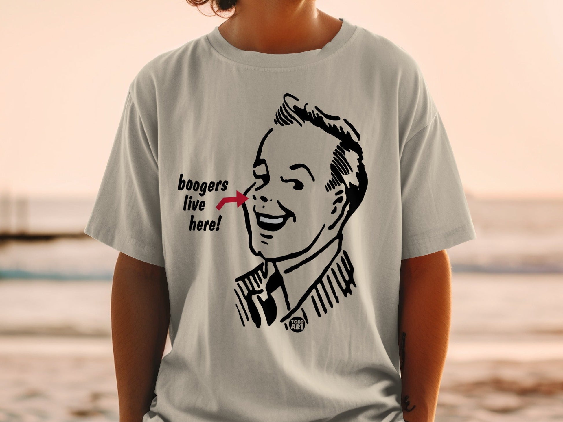 Graphic tee with cartoon man pointing to text that reads "boogers live here".