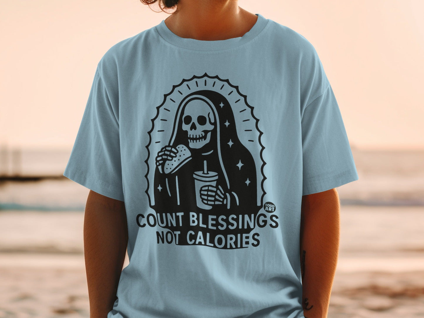Skeleton holding hamburger and drink, "Count Blessings Not Calories" text.