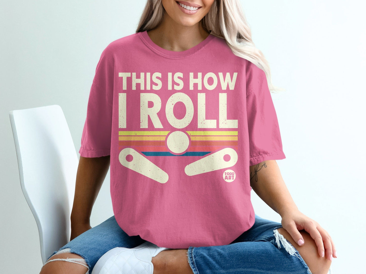 Pink t-shirt with "THIS IS HOW I ROLL" and a pinball machine graphic.