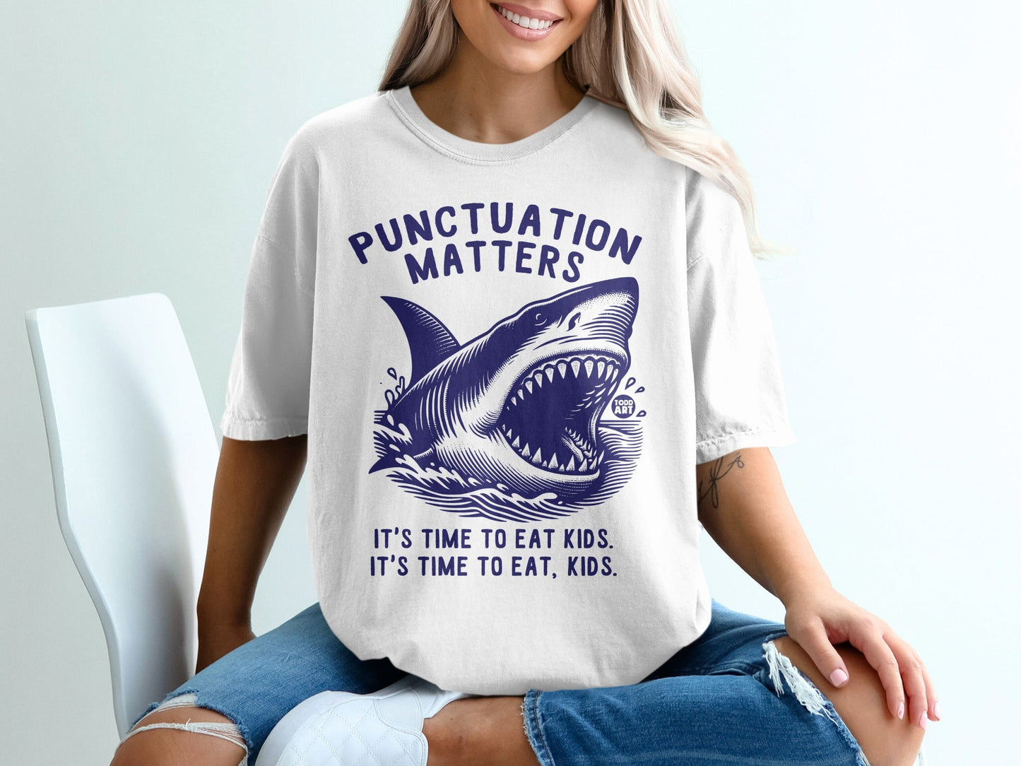 White t-shirt with a shark illustration and the text "PUNCTUATION MATTERS" and "IT'S TIME TO EAT KIDS."