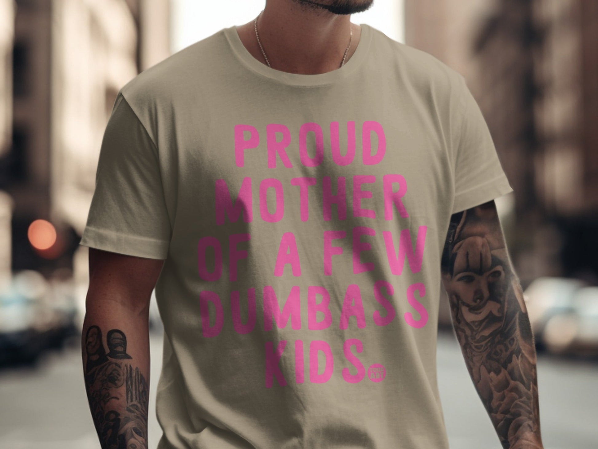 Tan t-shirt with pink text "Proud Mother of a Few Dumbass Kids."