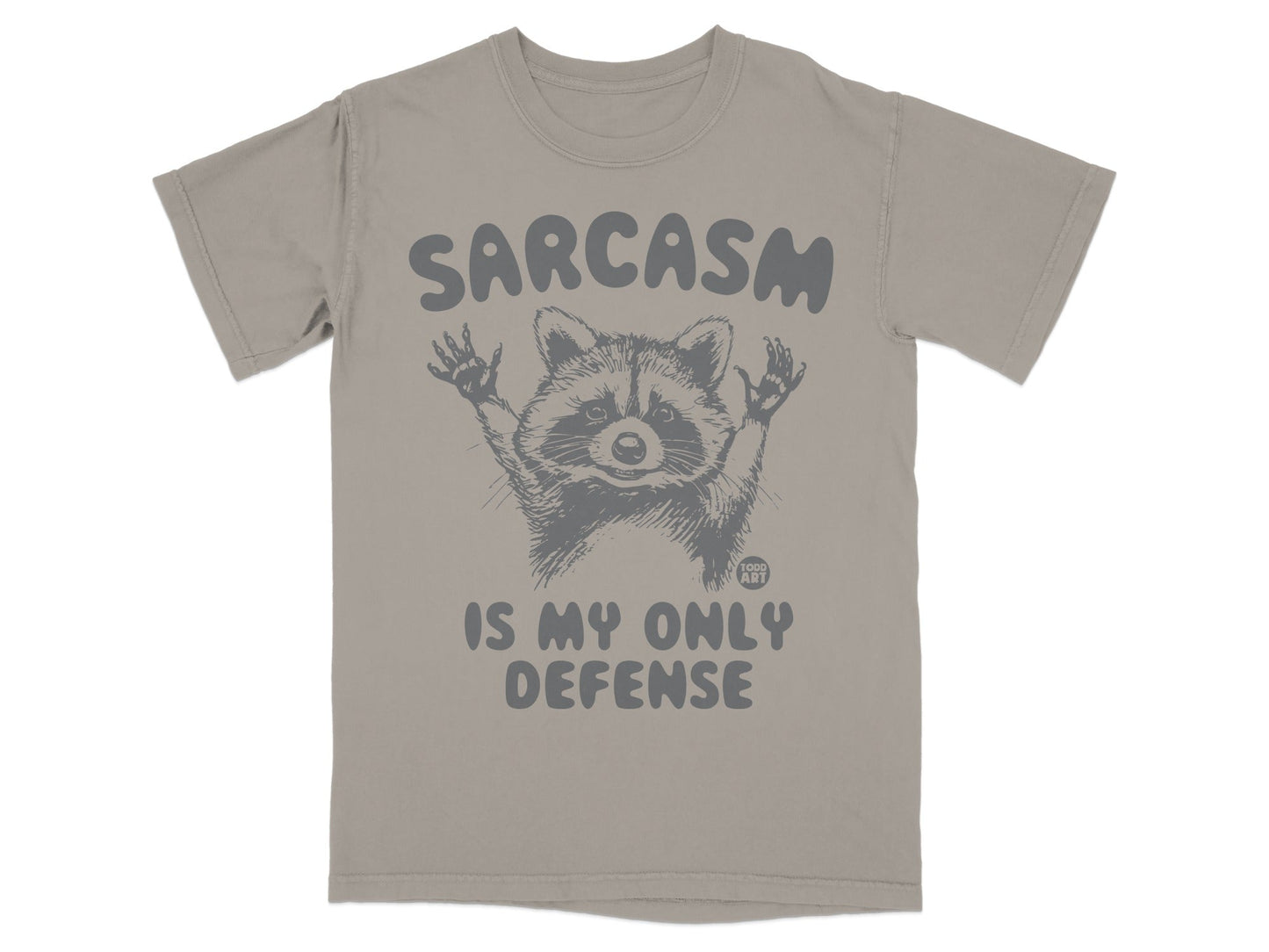 Gray t-shirt with raccoon graphic and text "SARCASM IS MY ONLY DEFENSE".