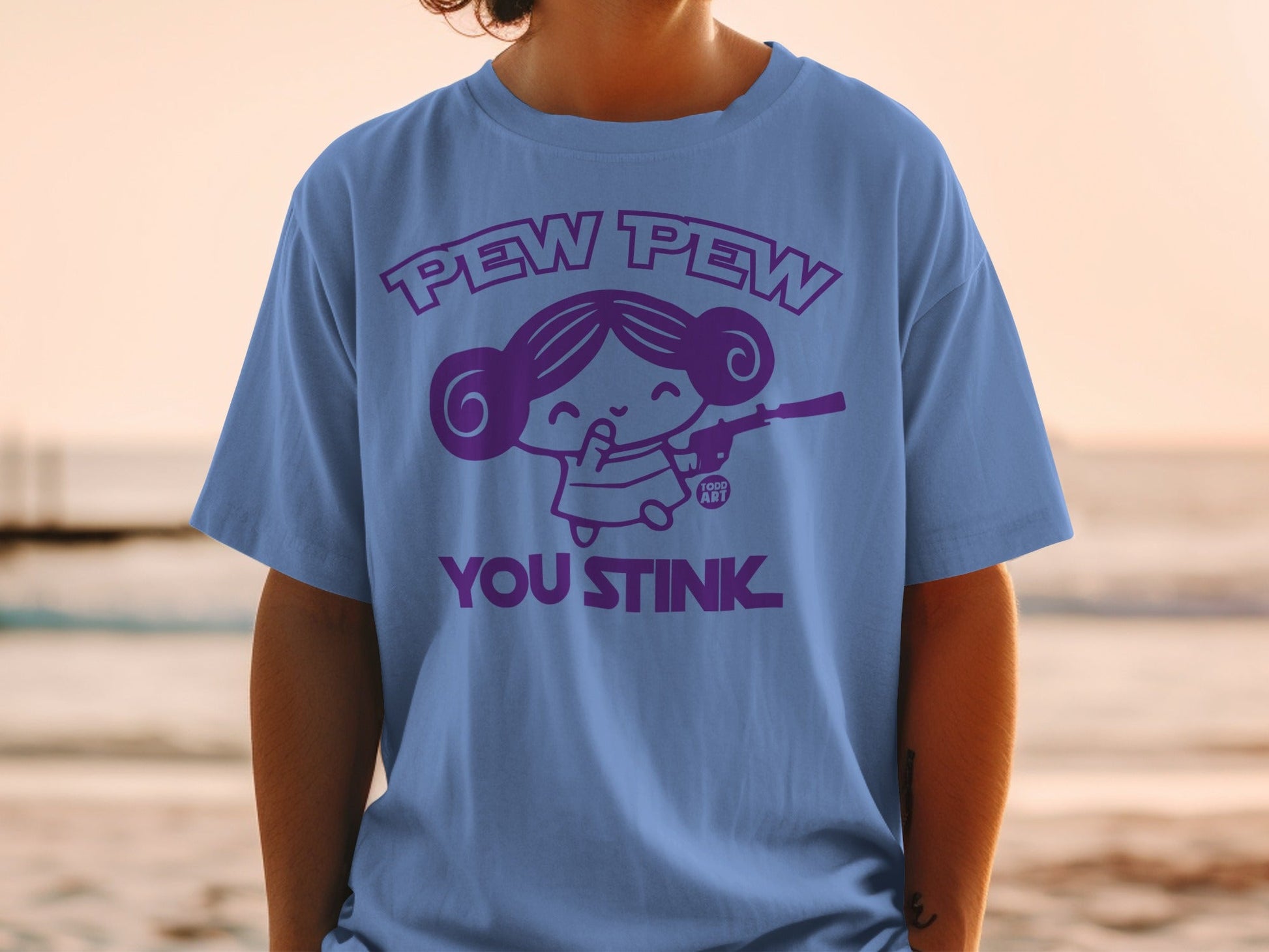 Purple t-shirt with cartoon character saying "Pew Pew You Stink".