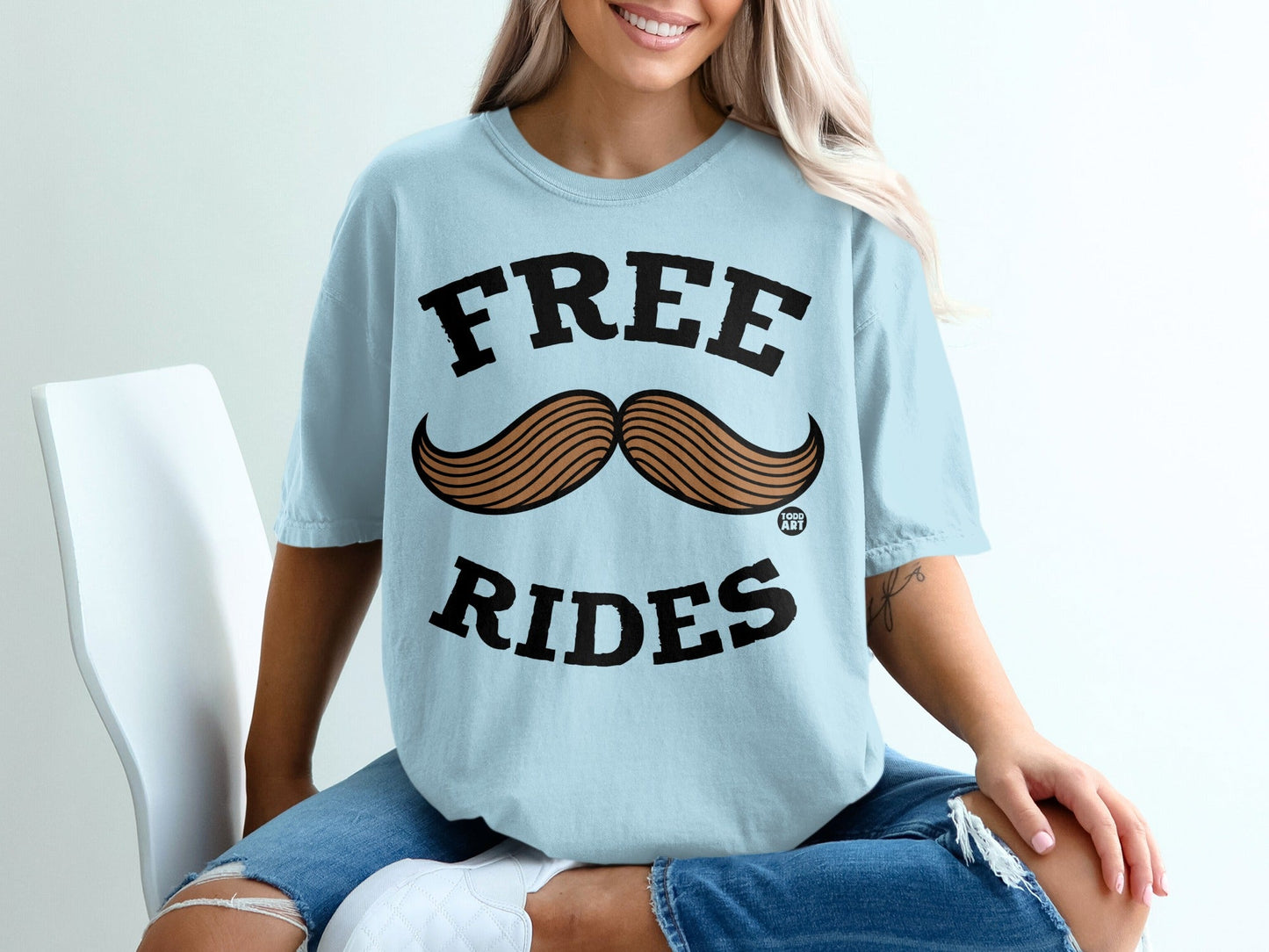 Light blue t-shirt with "FREE RIDES" and a mustache graphic.