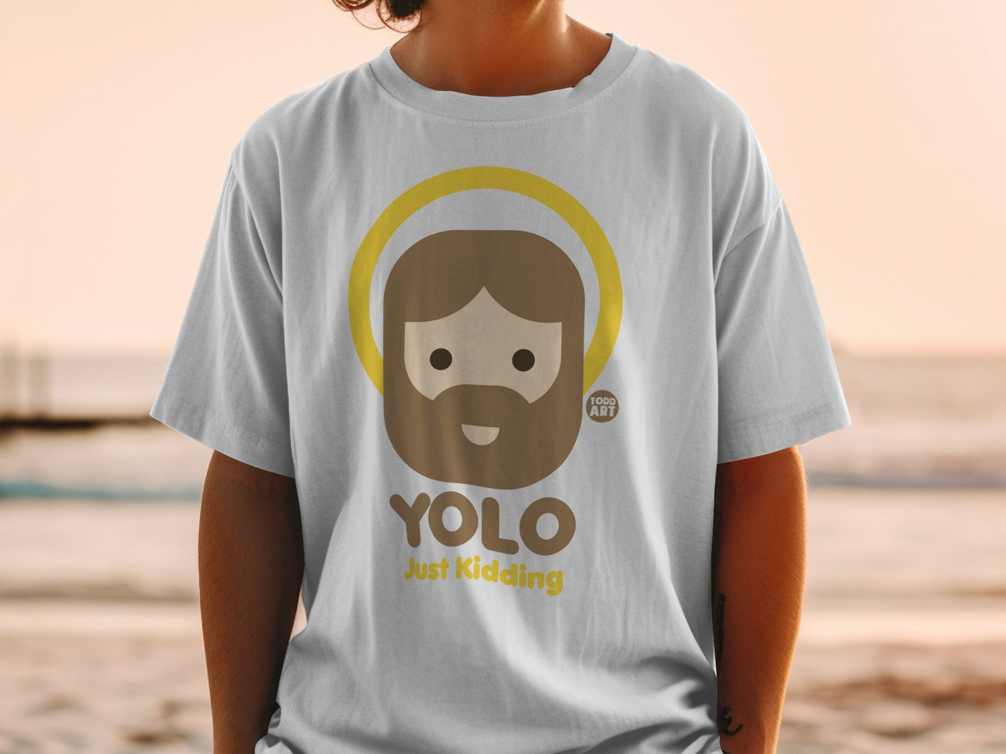 White t-shirt with "YOLO Just Kidding" and a haloed cartoon head.