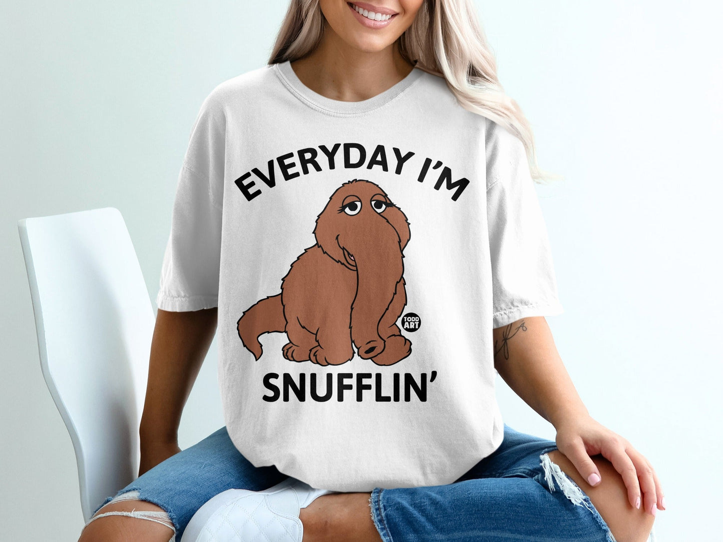 Woman wearing a white t-shirt with "Everyday I'm Snufflin'" and Cookie Monster.