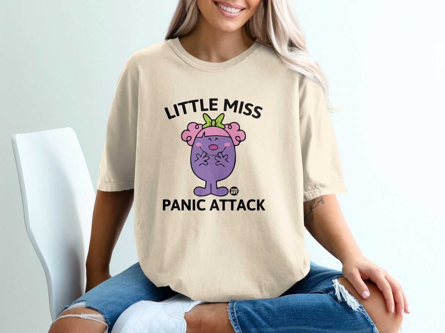 Cream t-shirt with "Little Miss Panic Attack" text and cartoon character.