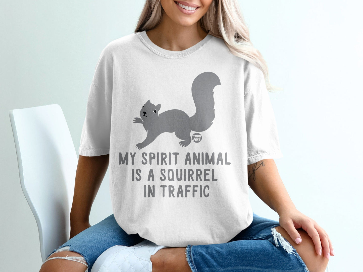 White t-shirt with a squirrel graphic and the text "MY SPIRIT ANIMAL IS A SQUIRREL IN TRAFFIC".