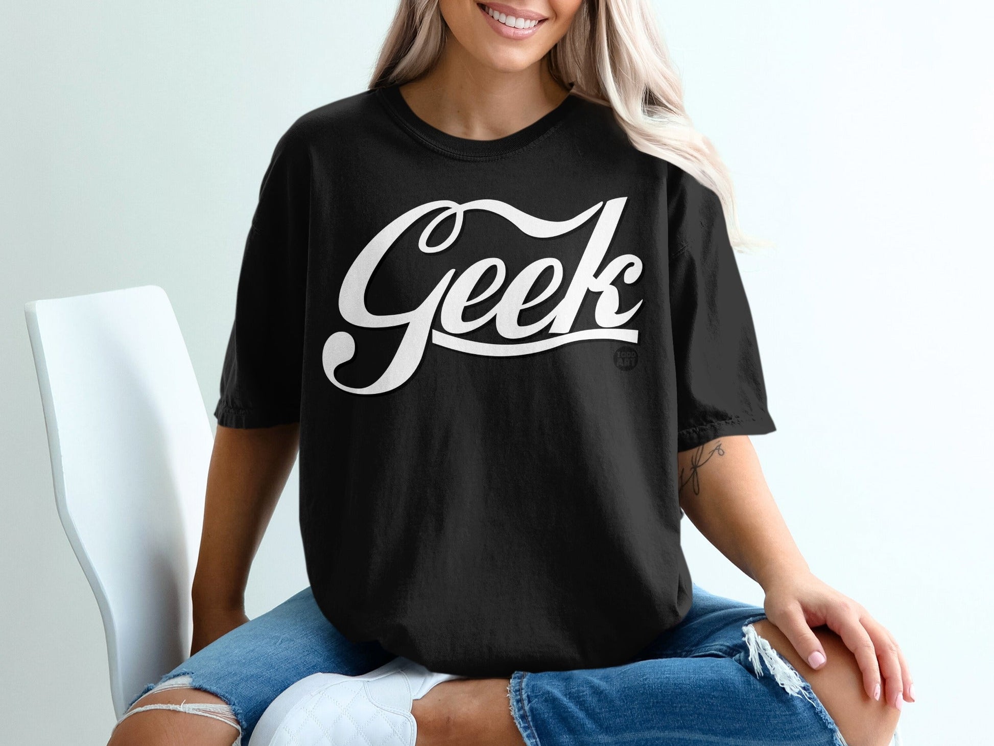 Black t-shirt with "Geek" in white cursive text worn by a woman.