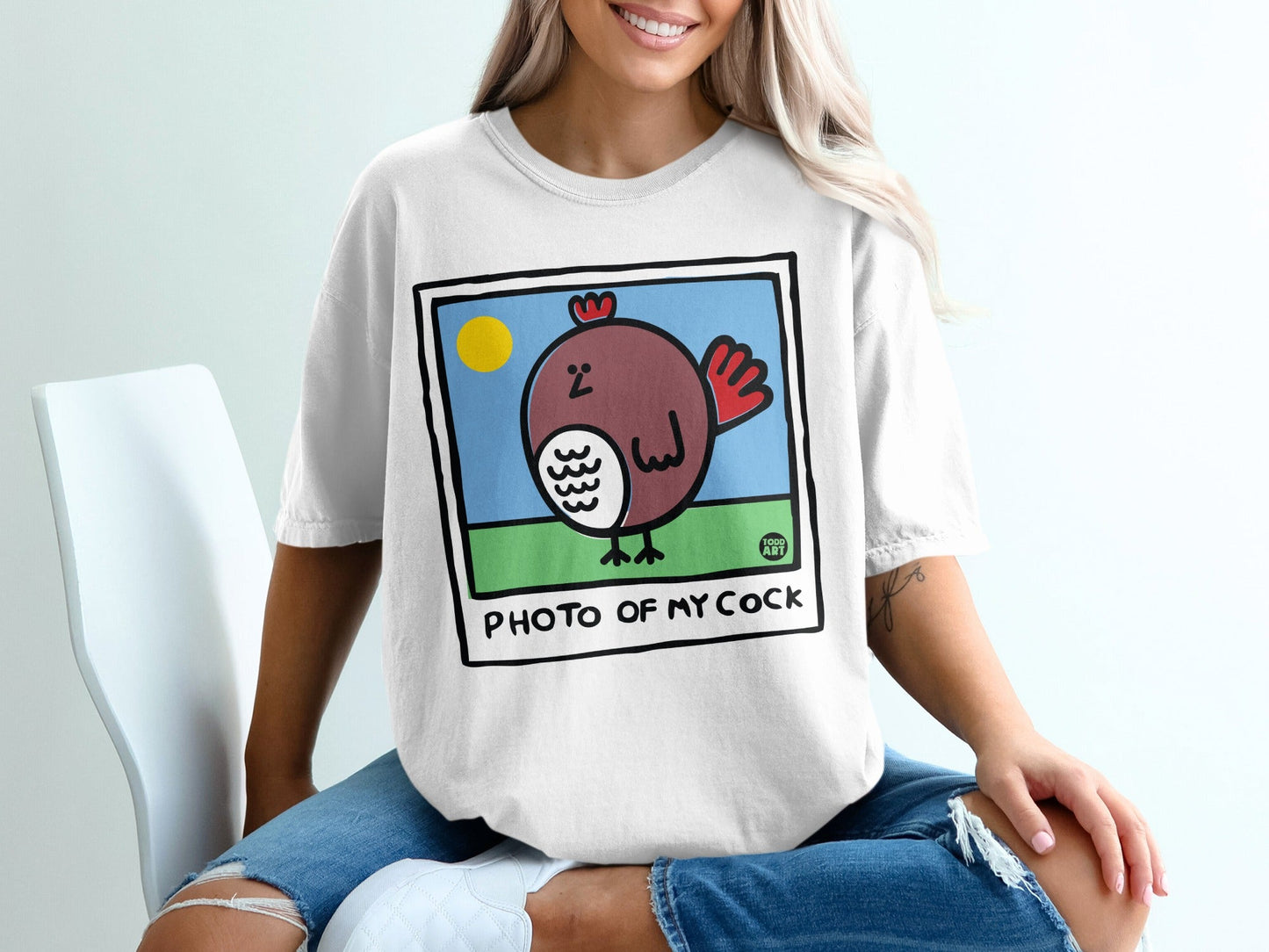 Cartoon chicken in a framed picture on a white t-shirt.