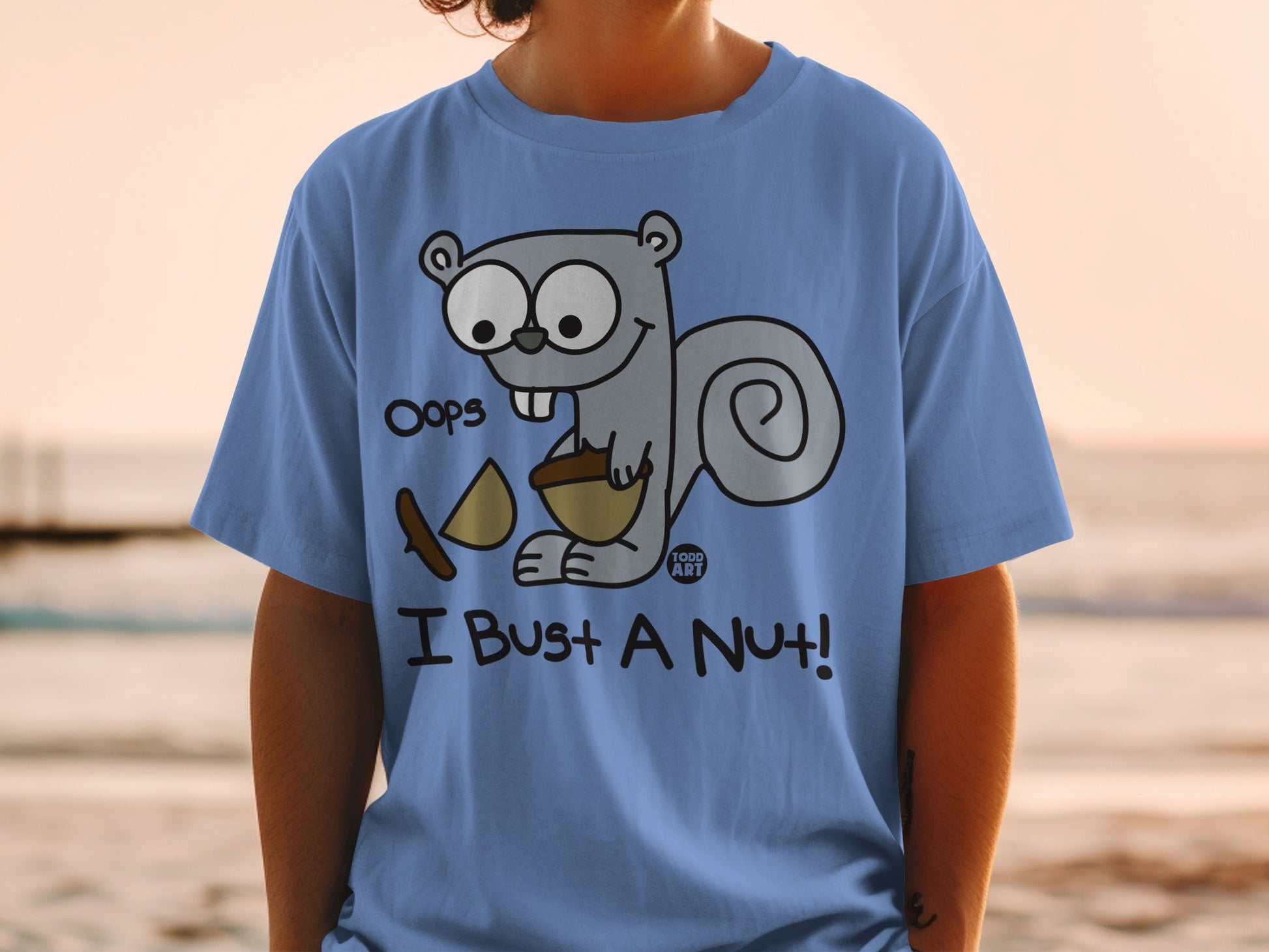 Blue t-shirt with a cartoon squirrel saying "Oops! I Bust a Nut!".