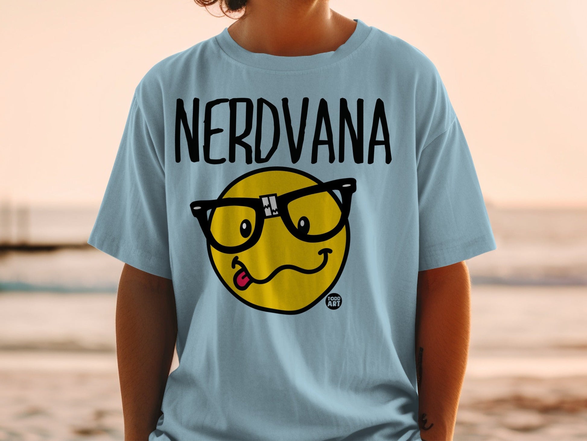 Light blue t-shirt with "NERDVANA" text and a smiley face wearing glasses.