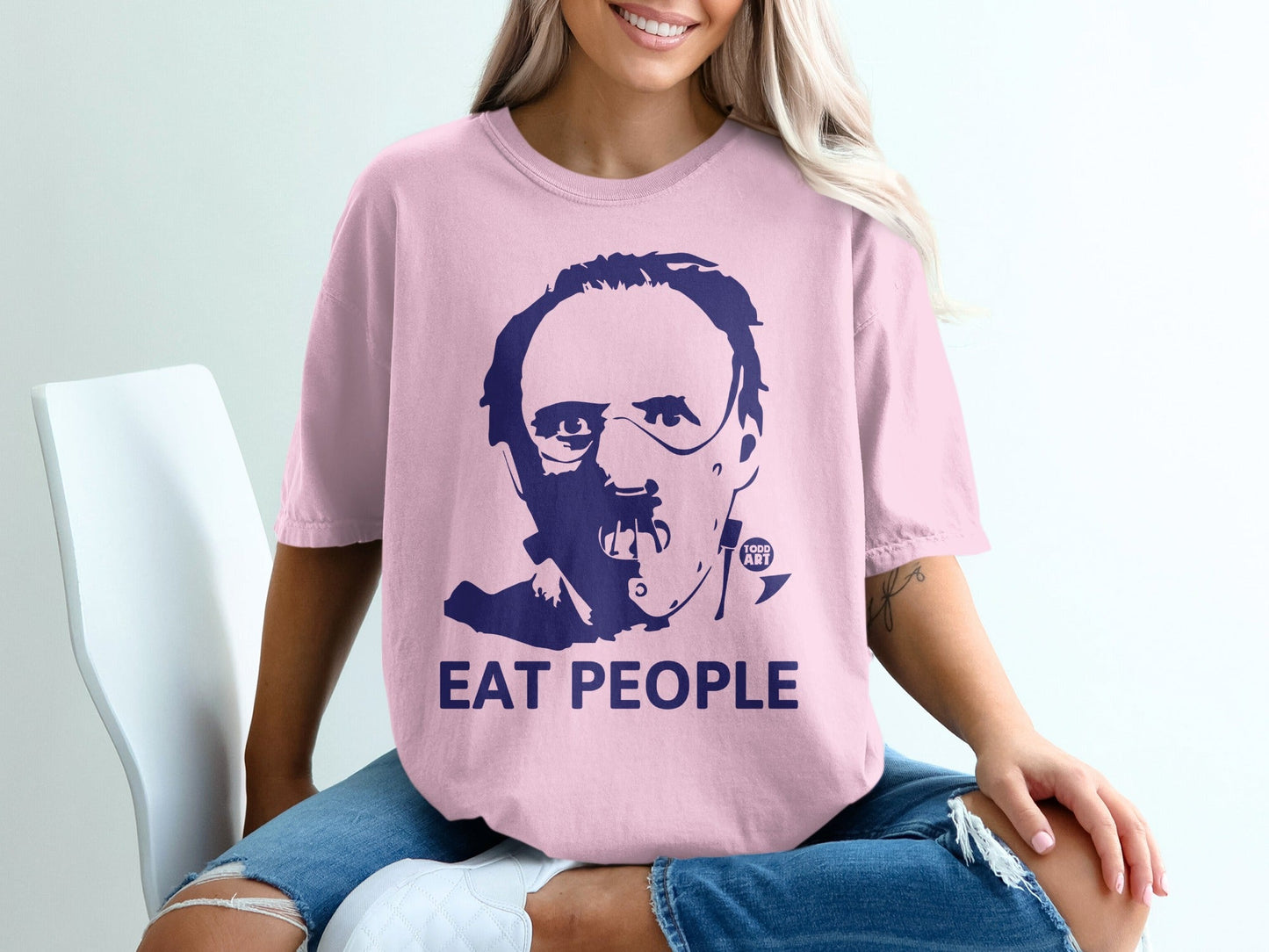 Pink t-shirt with a dark blue graphic of Hannibal Lecter's face and text "EAT PEOPLE".