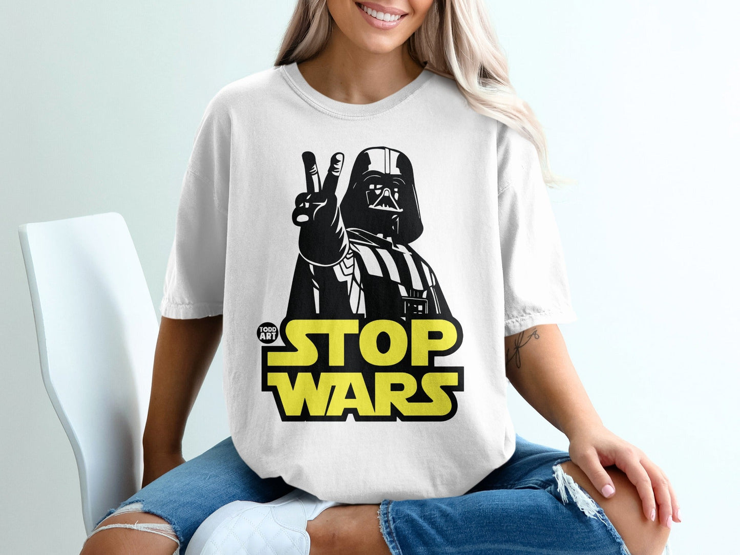 Darth Vader giving peace sign on white t-shirt with "STOP WARS" text.
