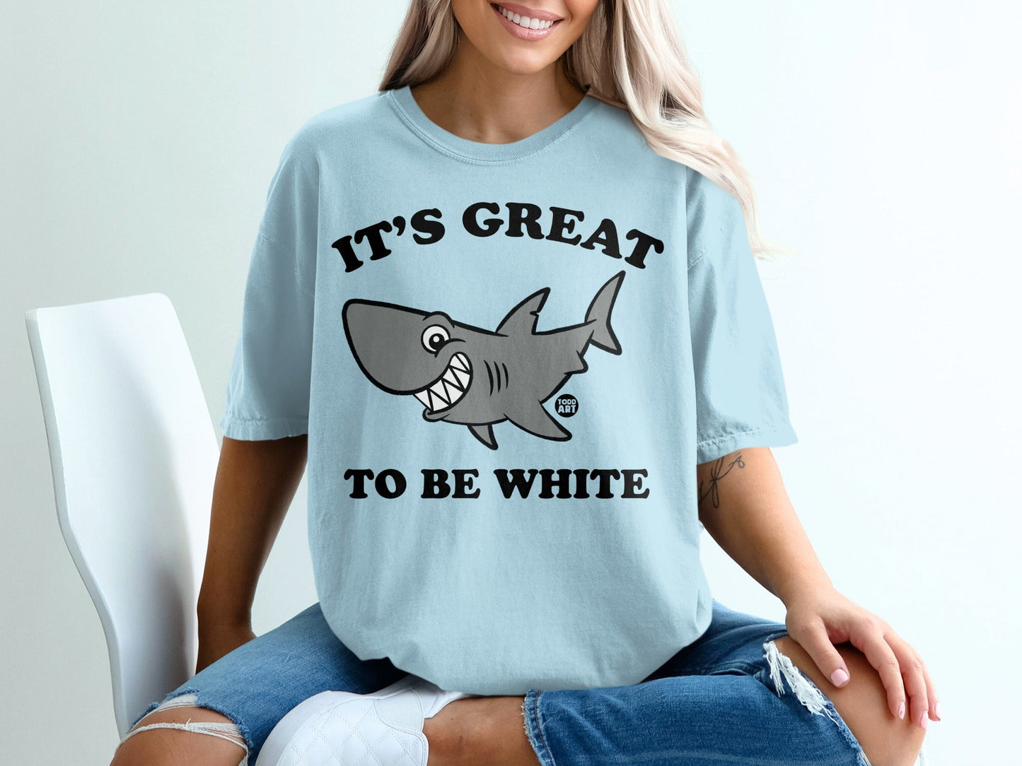 Light blue t-shirt with smiling cartoon shark and text "It's Great to Be White".