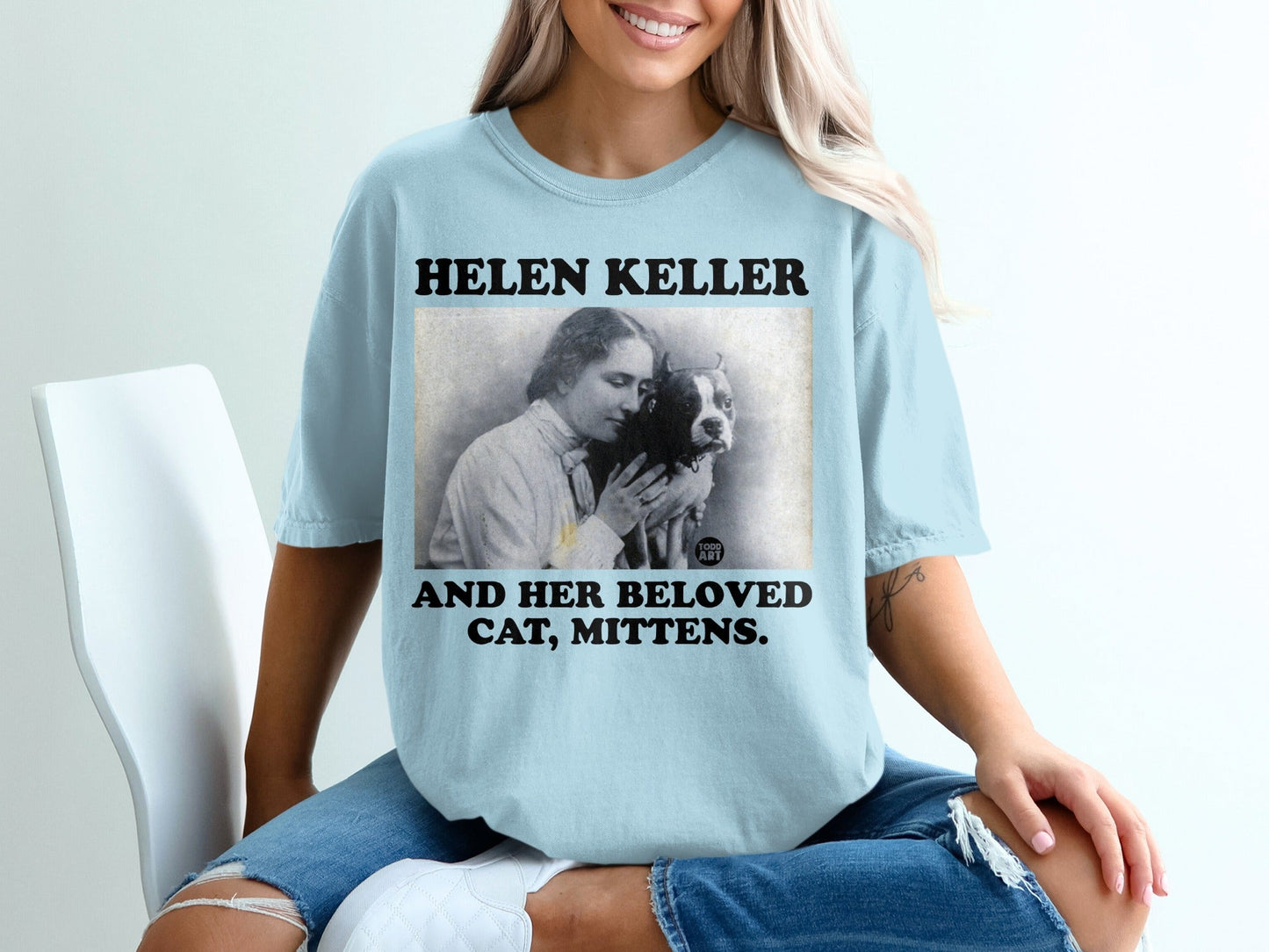 Helen Keller with her cat Mittens, text says "Helen Keller and her beloved cat, Mittens."