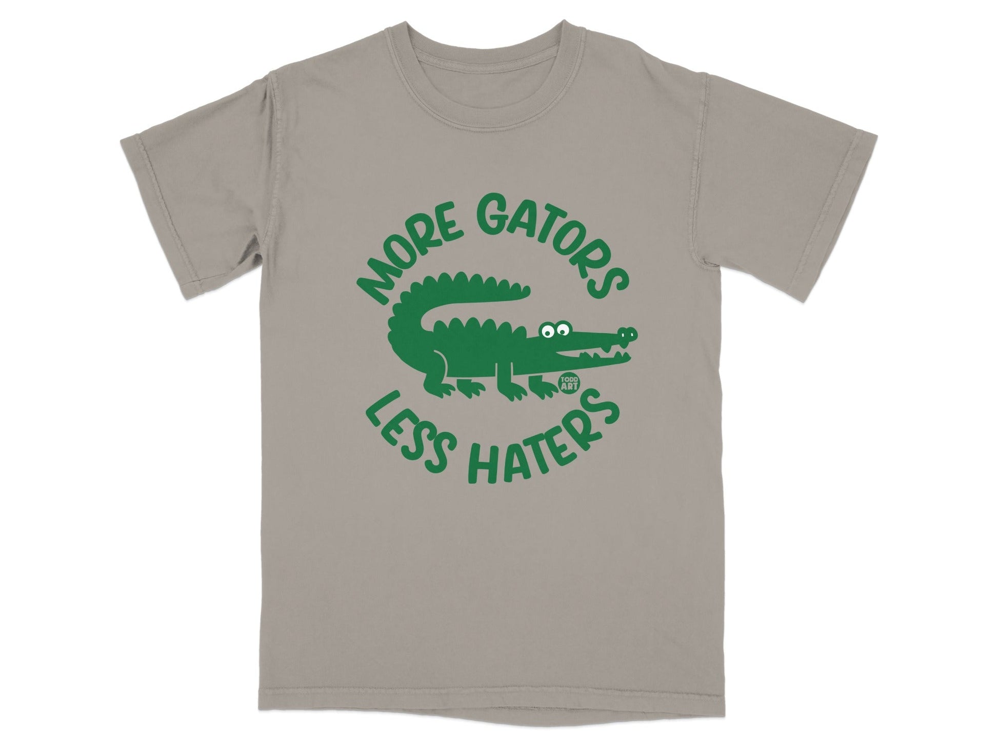 Green alligator graphic on a taupe t-shirt with text "MORE GATORS LESS HATERS".