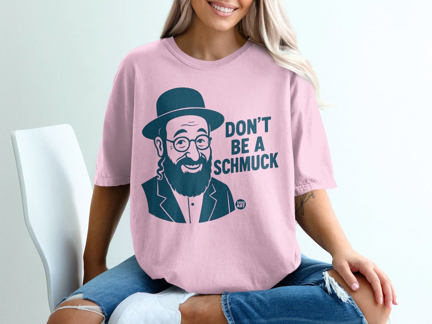 Pink t-shirt with "Don't Be a Schmuck" and a portrait of a bearded man.