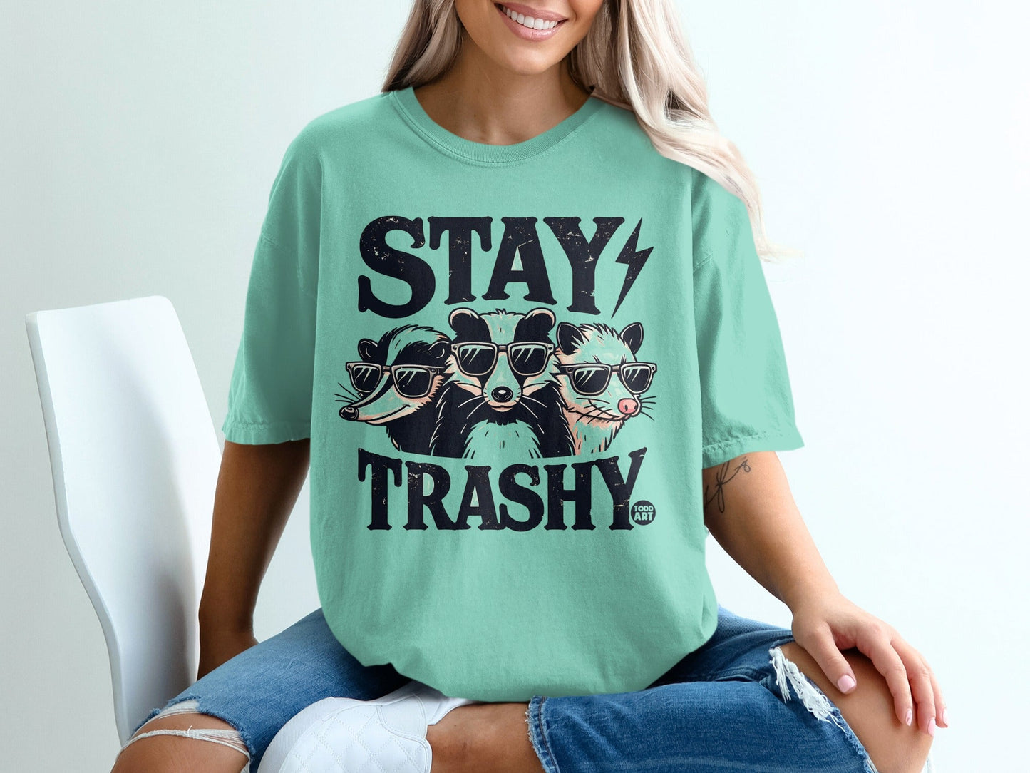 Three raccoons wearing sunglasses with "STAY TRASHY" text.